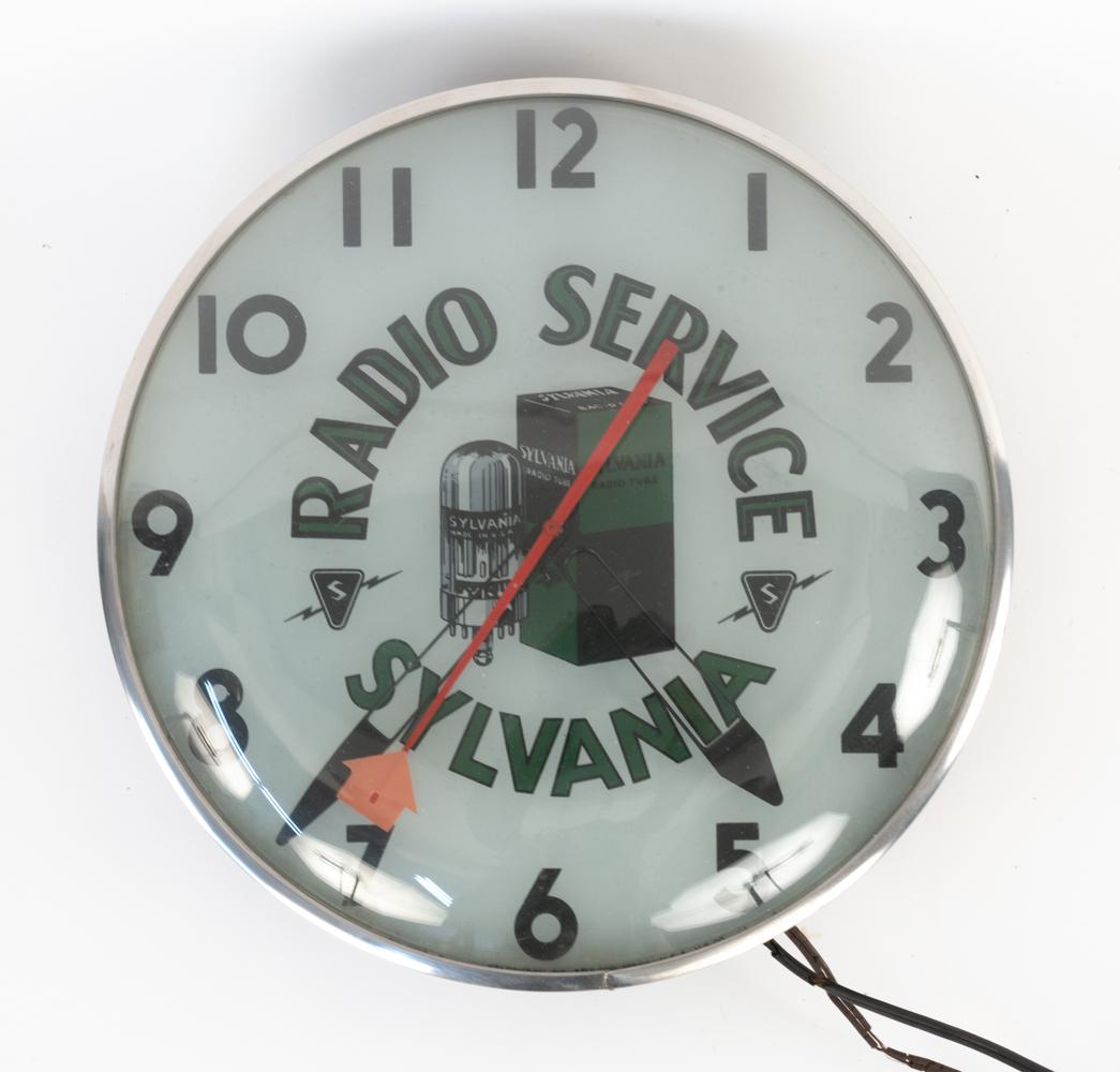 ORIGINAL SYLVANIA TUBE ADVERTISING CLOCK, C. WWII: This is a beautiful piece of WWII-era radio advertising. It is a Telechron illuminated electrical clock, number NP-296, which advertises radio servicing and the Sylvania tube brand and features a grap
