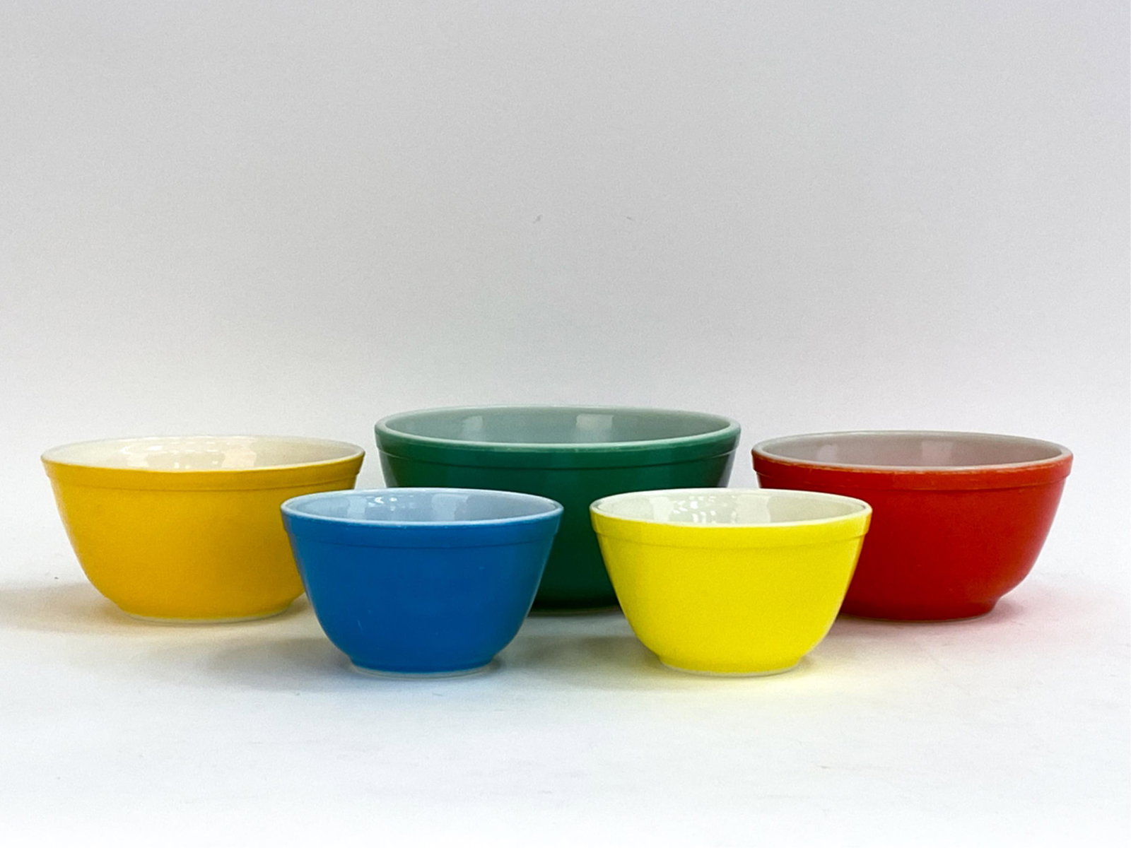 (5) VINTAGE PYREX COLORFUL MIXING BOWLS: (5) vintage colorful mixing bowls, marked Pyrex underneath. Dimensions: (Largest) H 4.25" x Dia. 9.25" Condition: Signs of use including some rubbing and surface scratches.