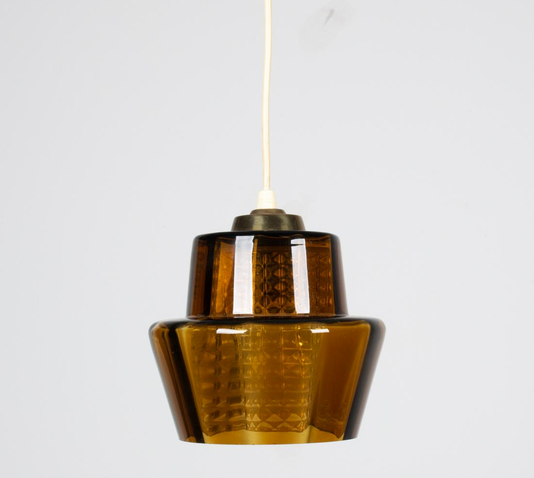 ATTR. ORREFORS GLASS PENDANT LIGHT: Dimensions: (Pendant only) H 7" x Dia. 7"; cord measures 22" long. Condition: Wiring not tested. A few tiny flea bites/scallops to glass; patina and minor finish loss to brass top mount; light toning