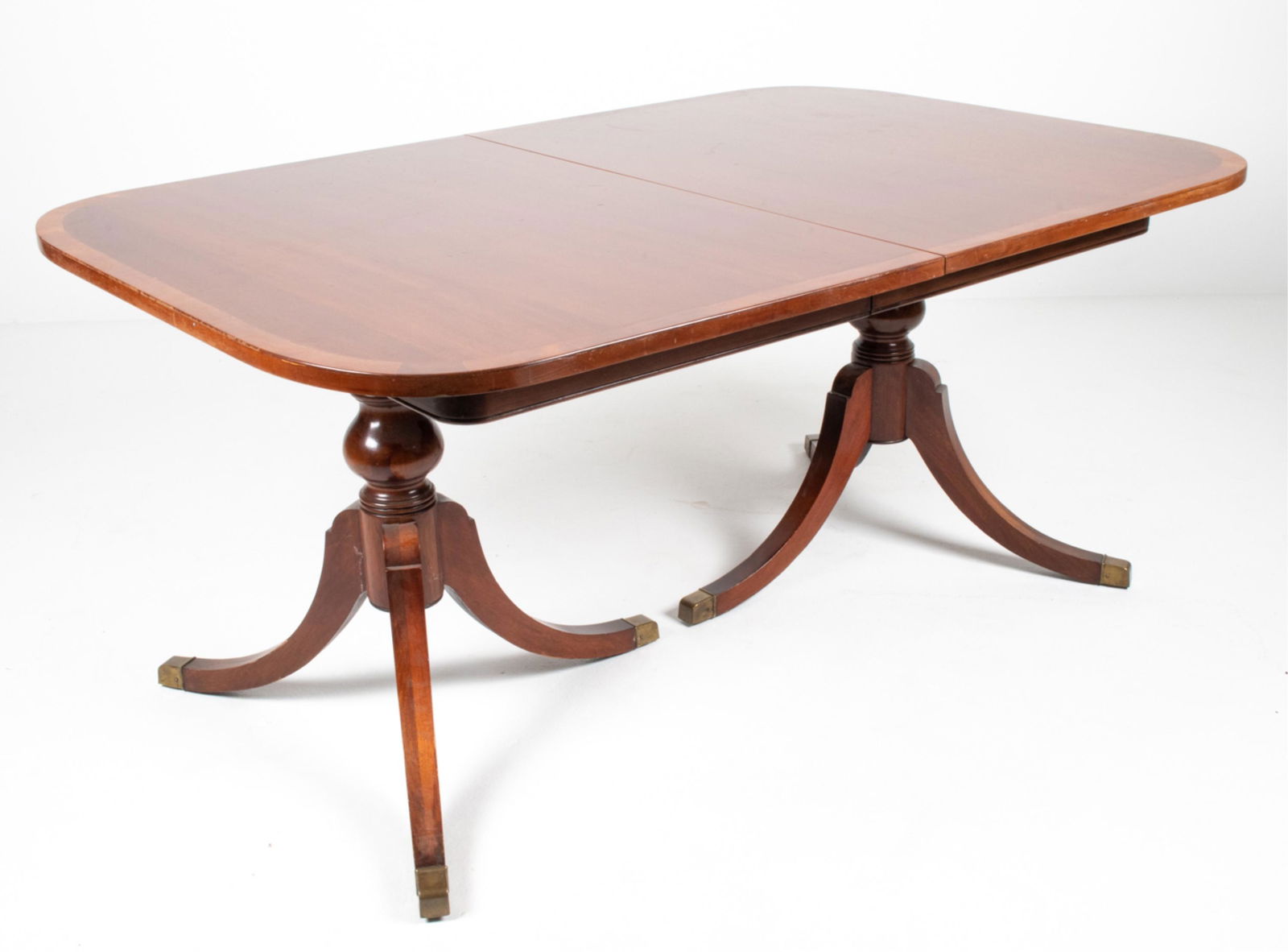 GEORGETOWN GALLERIES MAHOGANY DINING TABLE: 20th Century double-pedestal dining table in the style of Duncan Phyfe, labeled Georgetown Galleries on apron. Includes (1) leaf. Dimensions: (Without leaf) H 30" x W 67" x D 44"; leaf measures 12" wi