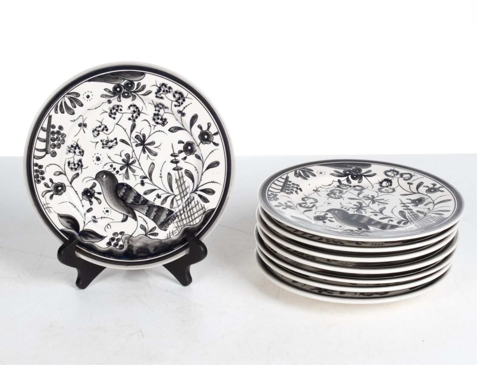 (8) CASAFINA PORTUGAL HAND-PAINTED PLATES: Dessert or salad plates with hand-painted floral and bird motifs. Casafina for Bergdorf Goodman; signed underneath. Dimensions: Dia. 9.5" Condition: One plate with small nick to glaze at rim; possibly
