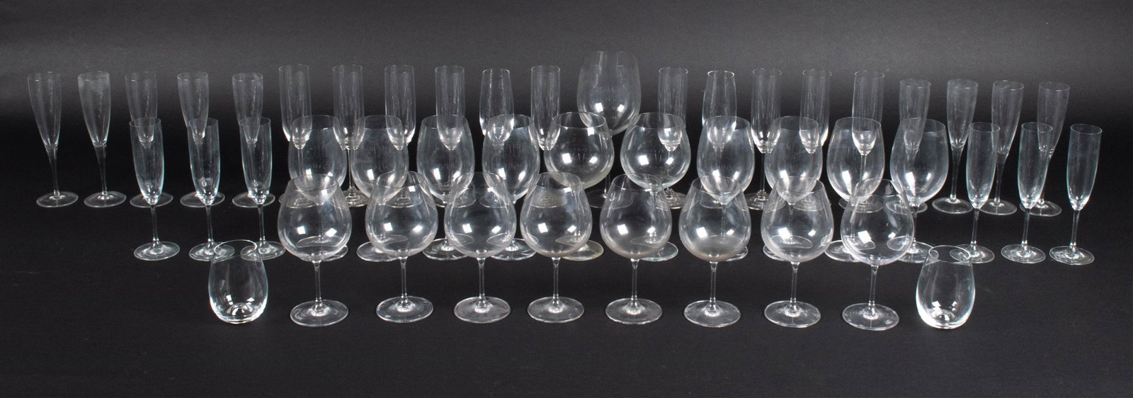 GROUPING OF FINE CRYSTAL STEMWARE; RIEDEL, TIFFANY: Large grouping of signed crystal stemware, including: (8) Riedel Bordeaux wine goblets, (8) Riedel Burgundy wine goblets; (15) Riedel champagne flutes, (9) Tiffany & Co. champagne flutes, (1) oversize