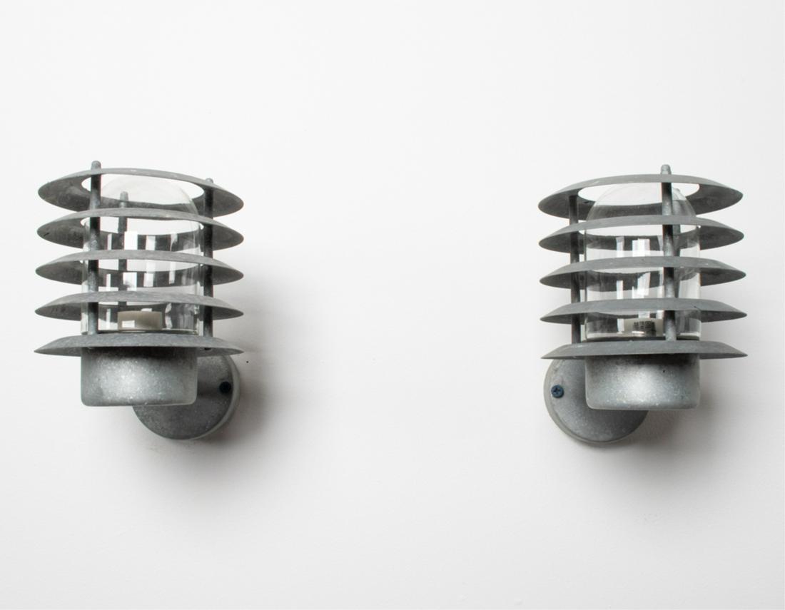 PAIR OF DANISH INDUSTRIAL MODERN OUTDOOR SCONCES: Louvered metal and glass, c. Late 20th Century, Dimensions: H 10" x W 7" x D 10.75" Condition: Wiring not tested. Natural weathering and patina consistent with age and outdoor exposure. A few house pa