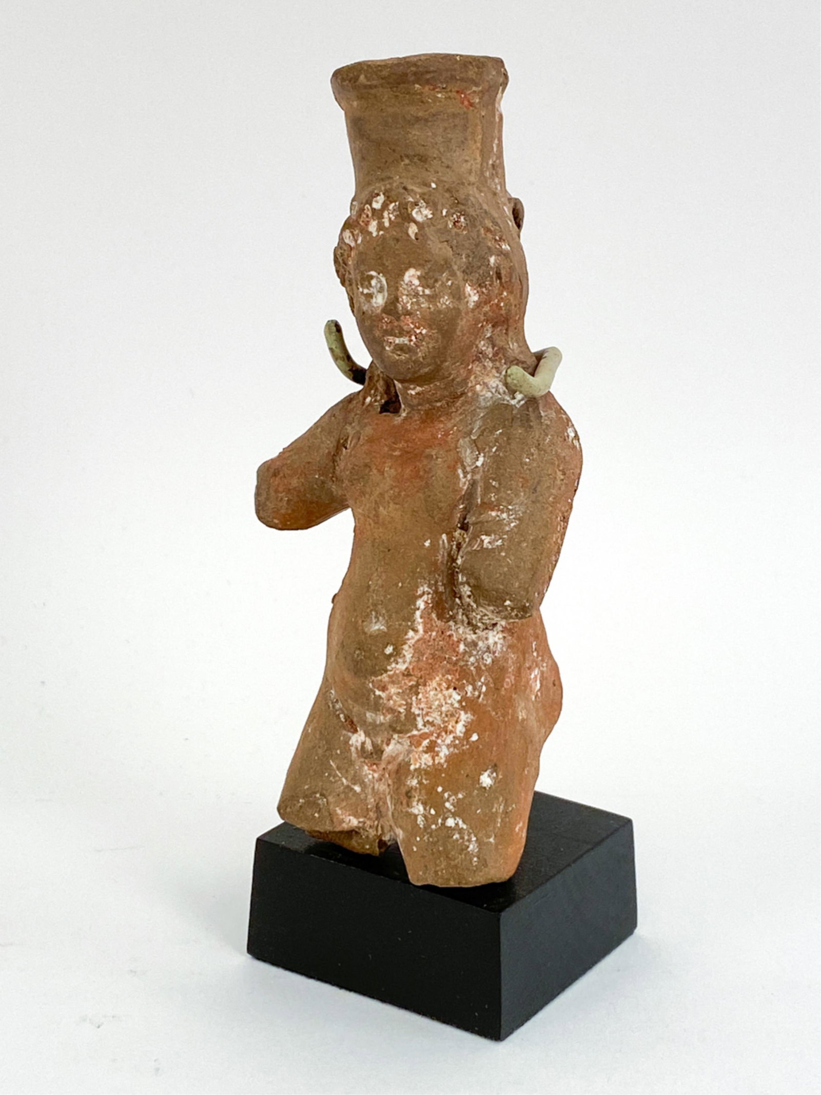 HELLENISTIC EGYPT 2ND/1ST C. BC TERRACOTTA: Terracotta of standing youth, wearing a modius. Loop at back of modius pierced for hanging. Provenance: Bernheimer's Antique Art. With custom mount. Dimensions: (Sculpture) H 4.5" x W 2.25" x D 1.75",
