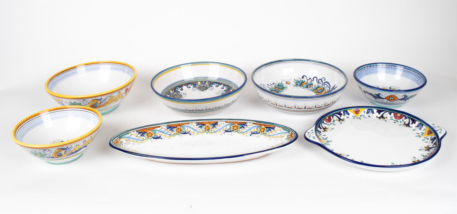 GROUPING OF CERAMICA ITALIAN MAJOLICA SERVEWARE: Grouping of contemporary hand-painted ceramic tableware by Ceramica. Includes: (1) oval platter, (1) handled round platter, (3) large salad or fruit bowls, and (2) serving bowls. Each piece is signed