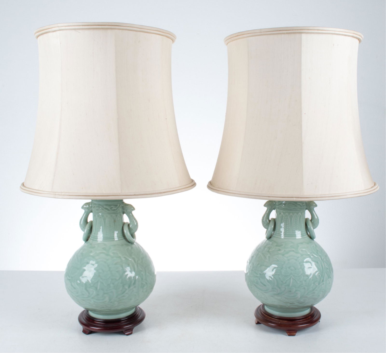PAIR OF CELADON PORCELAIN LAMPS: Dimensions: (With shades) H 32.5" x Dia. 18" Condition: Wiring not tested. One finial loose. Porcelain with light natural crazing; no apparent chips or cracks. A few finish losses to mounts; a couple