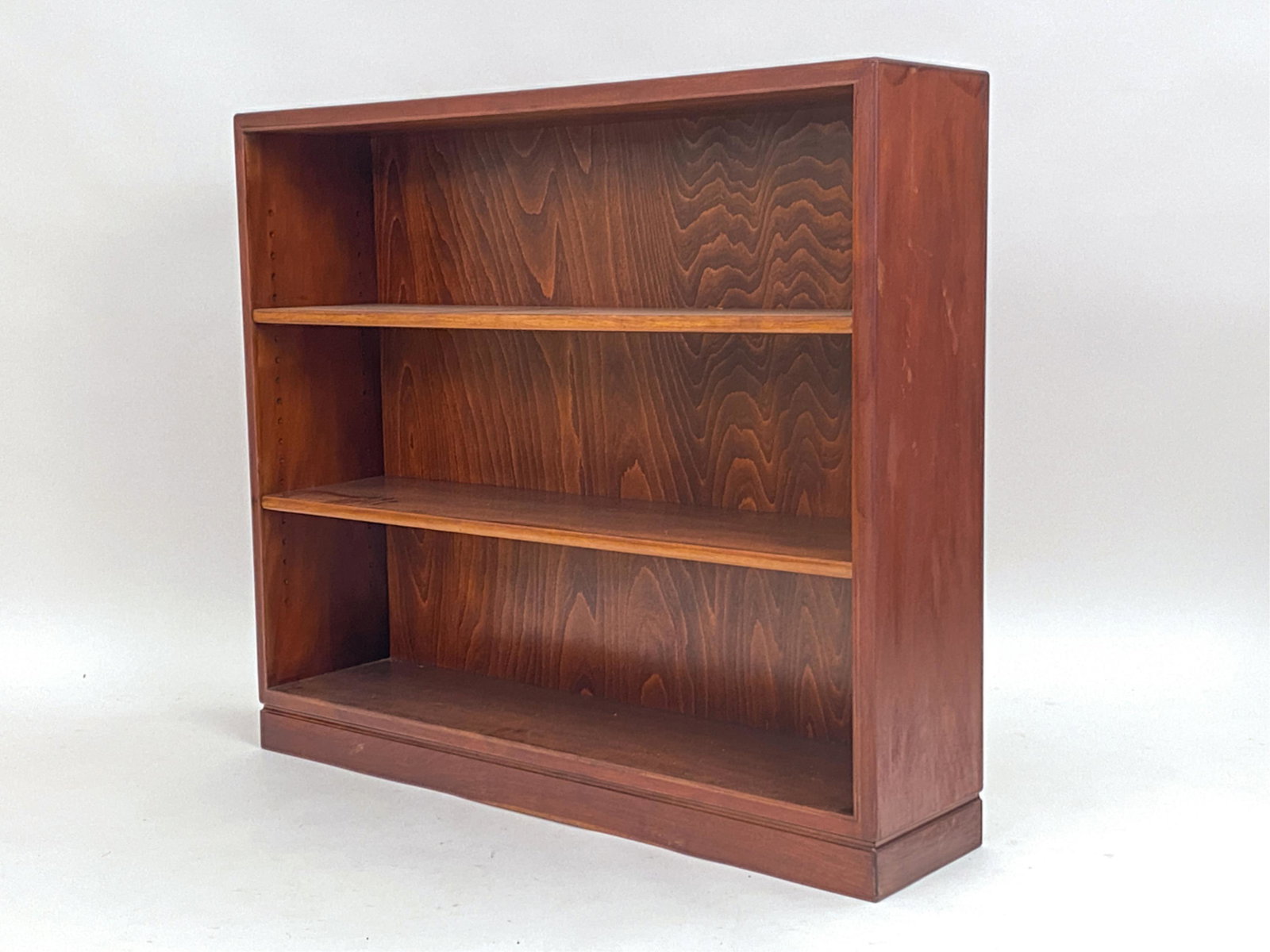 FRITS HENNINGSEN MID-CENTURY ROSEWOOD BOOKCASE: Unsigned. Adjustable shelves. Dimensions: H 37.25" x W 43.25" x D 9.75" Condition: Areas of uneven finish. Small loss to proper left side top corner. D203