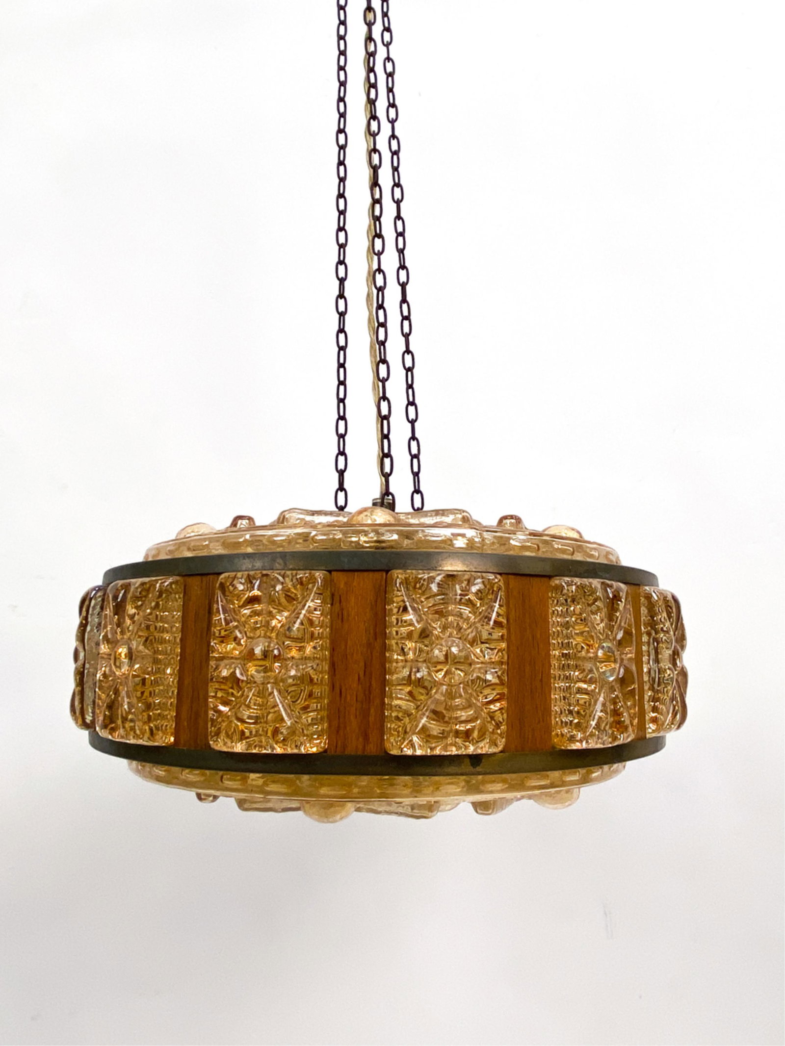 ORREFORS MID-CENTURY GLASS & TEAK PENDANT LIGHT: Unmarked. Textured amber glass with teak panels inset. Dimensions: (To ceiling) H 56" x Dia 13.5" Condition: Finish wear to brass elements consistent with age. Untested. Chains are rusted. D086
