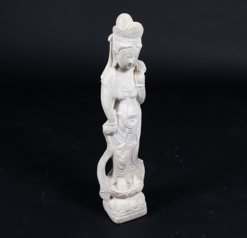CARVED ALABASTER GUANYIN SCULPTURE: Apparently unsigned. Dimensions: H 28" x W 7" x D 5.75" Conditions: Chips to the base. Minor soiling spots on back. Natural patination throughout the stonework.