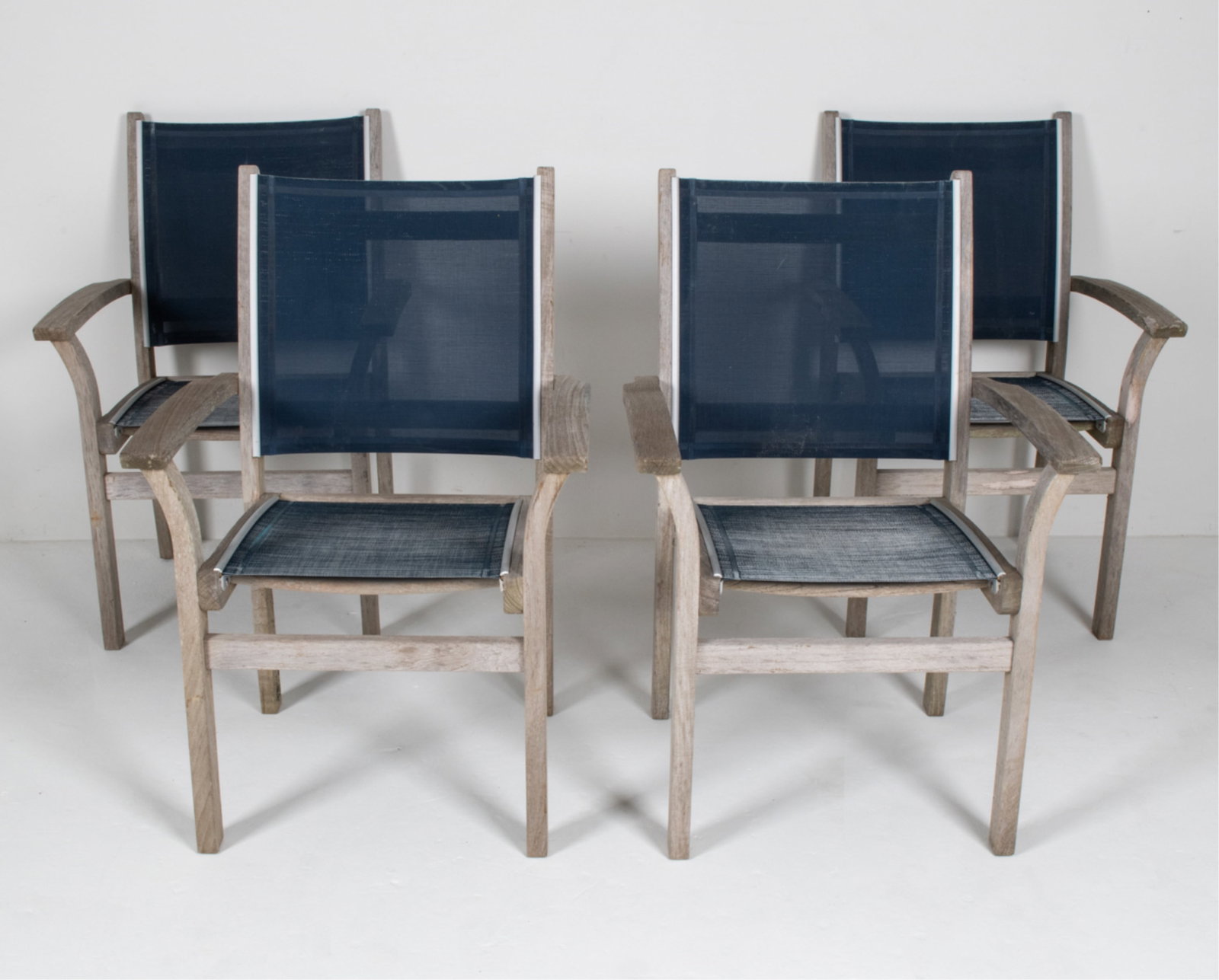 (4) KINGSLEY-BATE TEAK PATIO ARMCHAIRS: Dimensions: H 37" x W 24" x D 24" x SH 18" Condition: Wear consistent with age and light outdoor exposure, including fading to mesh, dings and water spots, a few stress cracks to wood, etc.