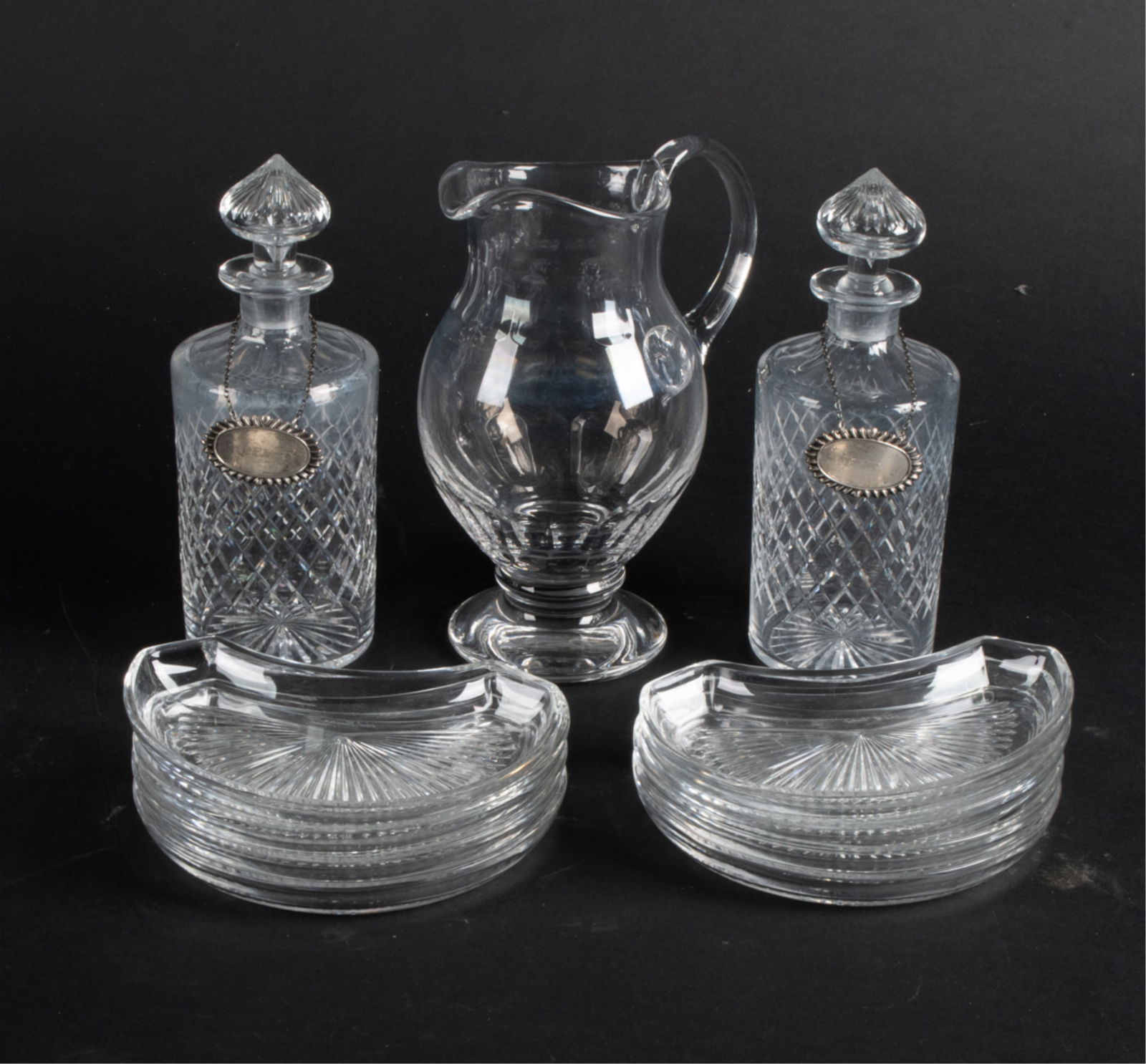 GROUPING OF SIGNED CRYSTAL INCL. YEOWARD, WEBB: Including: William Yeoward pitcher, pair of Thomas Webb cut crystal decanters with sterling silver labels reading "Sherry" and "Rye", and a set of (11) hand-signed Val St. Lambert canape plates. Dimen