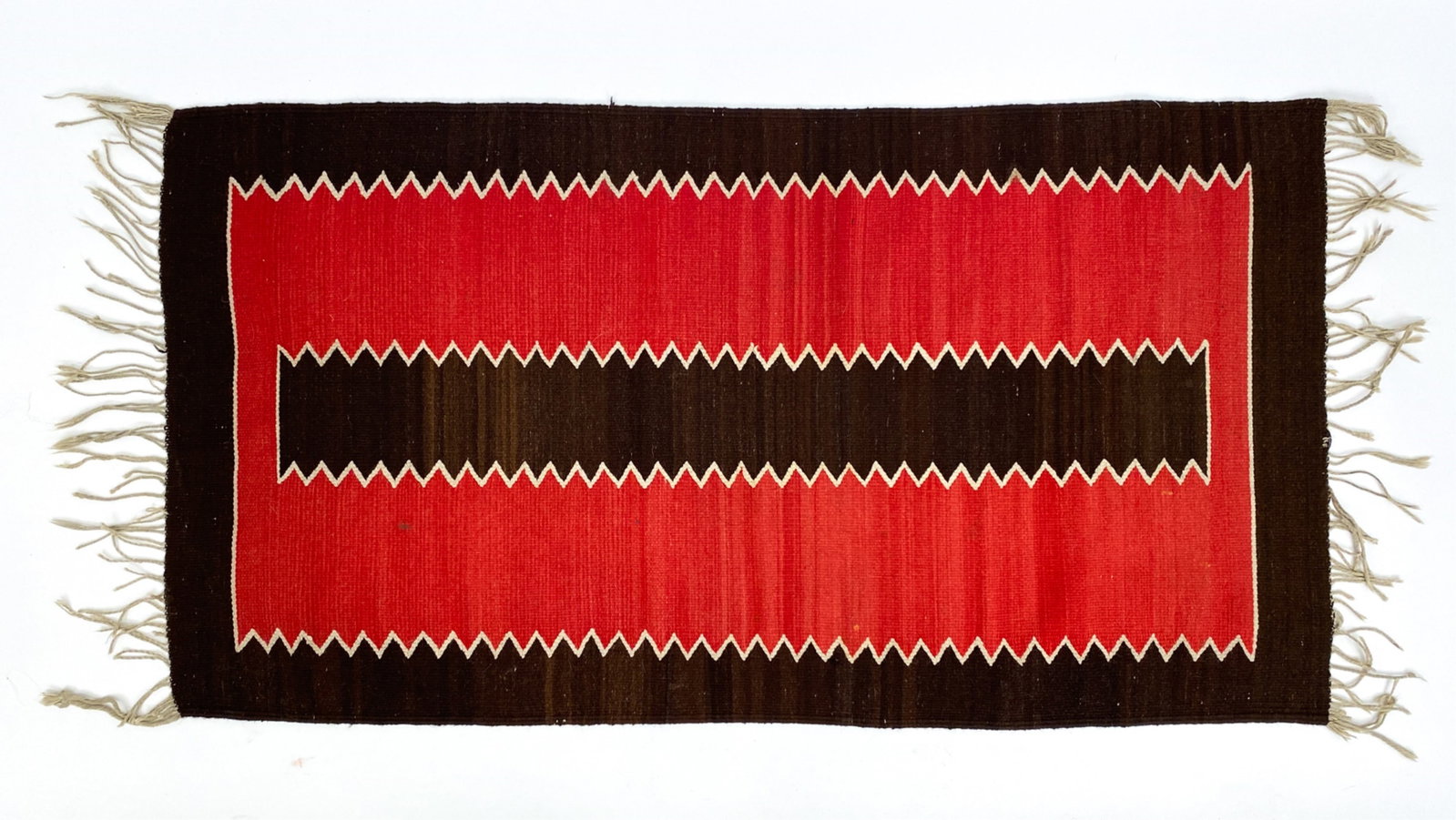 VINTAGE NAVAJO RUG: Some dye variations. Dimensions: L 57" x W 30" Condition: Some spotting.