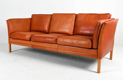 MOGENS HANSEN DANISH MODERN BRANDY LEATHER SOFA: Three-seat sofa in brandy leather and oak wood. Dimensions: H 27.5" x W 80" x D 30.5" x SH 17" Condition: Natural patination and wear to leather, including a few nicks and surface losses, scuffs and