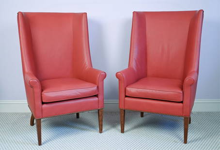 PAIR OF MODERN HIGH-BACK WING CHAIRS: Pair of contemporary wingback chairs with dramatic high backs, rolled arms, and tacked trim. No labels. Upholstered in brick-red leatherette. Dimensions: H 47.25" x W 29.25" x D 26.5" x SH 20" Conditi