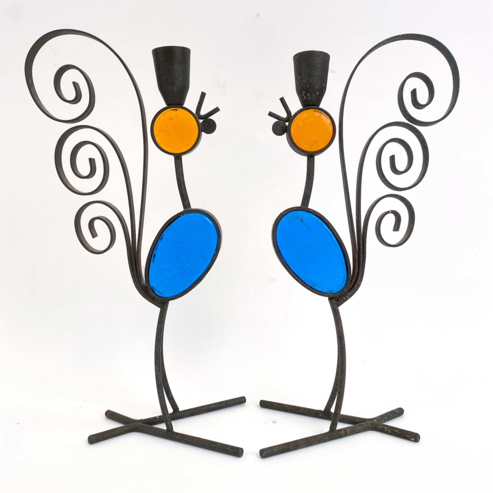 PAIR GUNNAR ANDER FOR YSTAD CHICKEN CANDLESTICKS: Iron with stained glass inserts. Mid-20th century. Dimensions: H 10.5" x W 3" x D 5" Condition: Finish wear consistent with age and use. One with a slight lean.