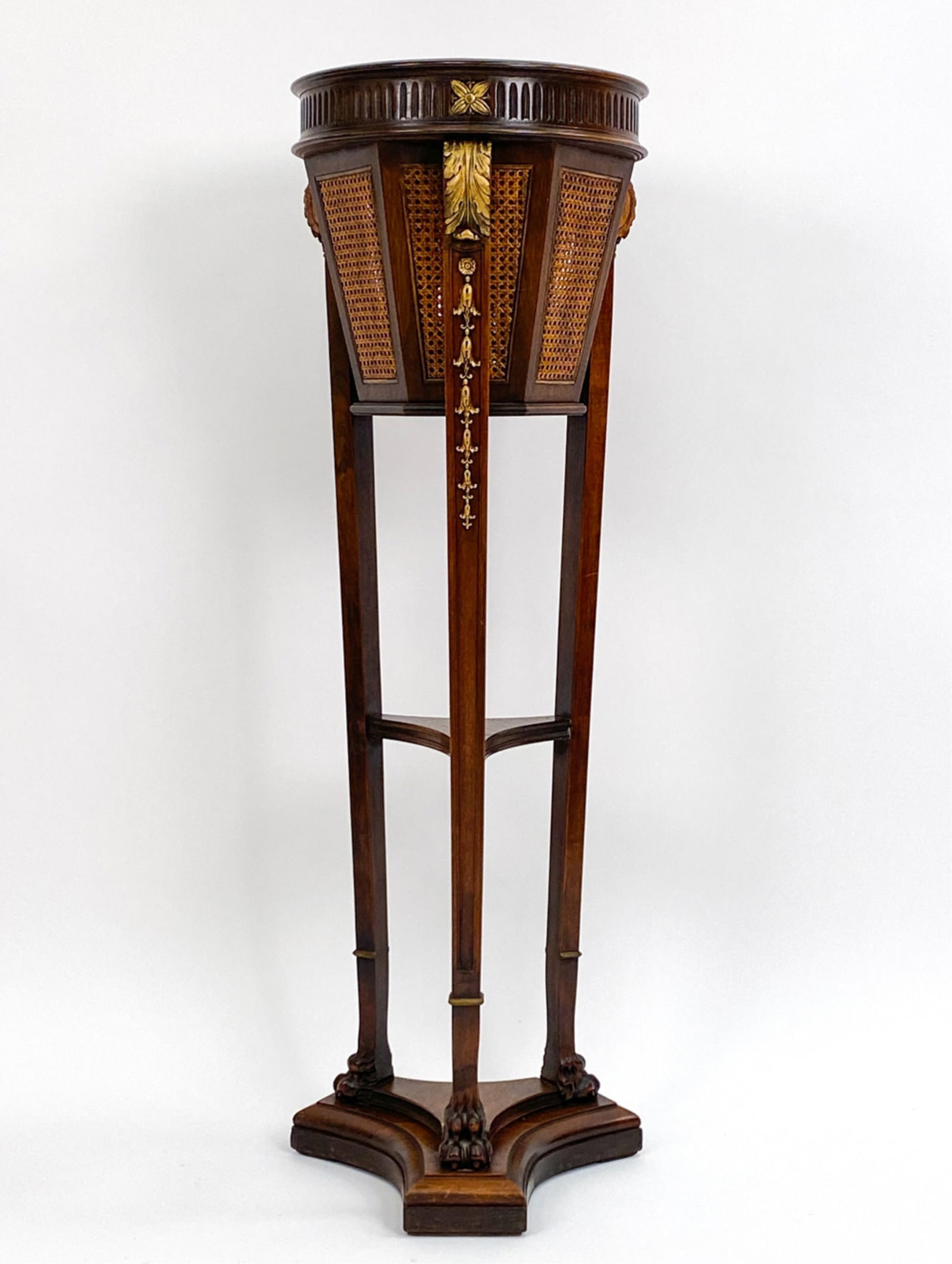 EMPIRE-STYLE TORCHIERE FORM PLANTER: Carved wood with faux gilding. Bucket with caned sides. Unmarked. Dimensions: H 44.5" x Dia. 14.25" Condition: Central spandrel separating from leg. Scattered surface marks. Some water staining on the