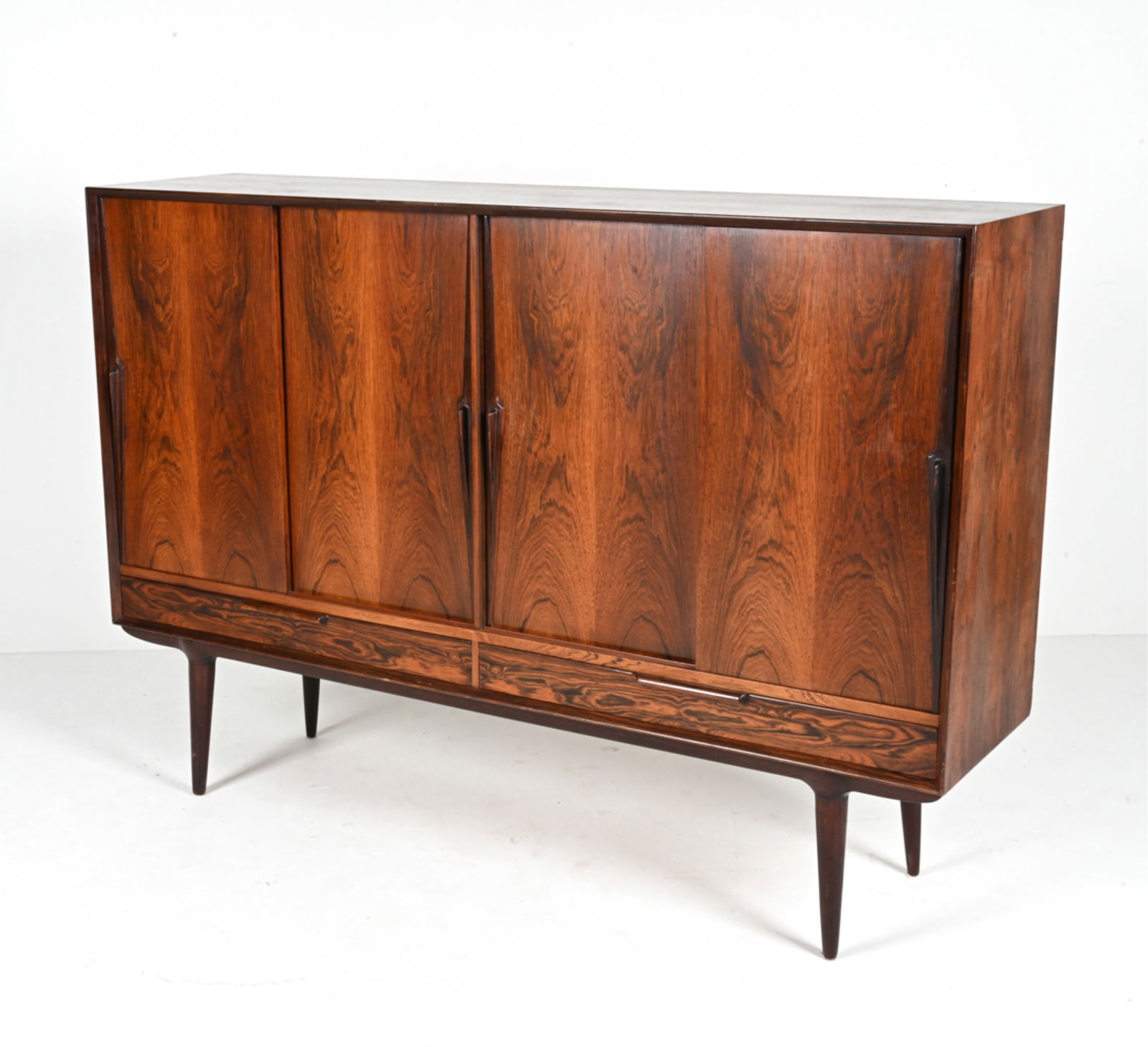 GUNNI OMANN MODEL 13 ROSEWOOD HIGHBOARD CABINET: An exceptional and rare Model 13 sideboard bar cabinet in luxurious rosewood, featuring Atomic-inspired sculpted handles and dovetailed interior joinery. Designed by Gunni Omann for Omann Jun, Denmark
