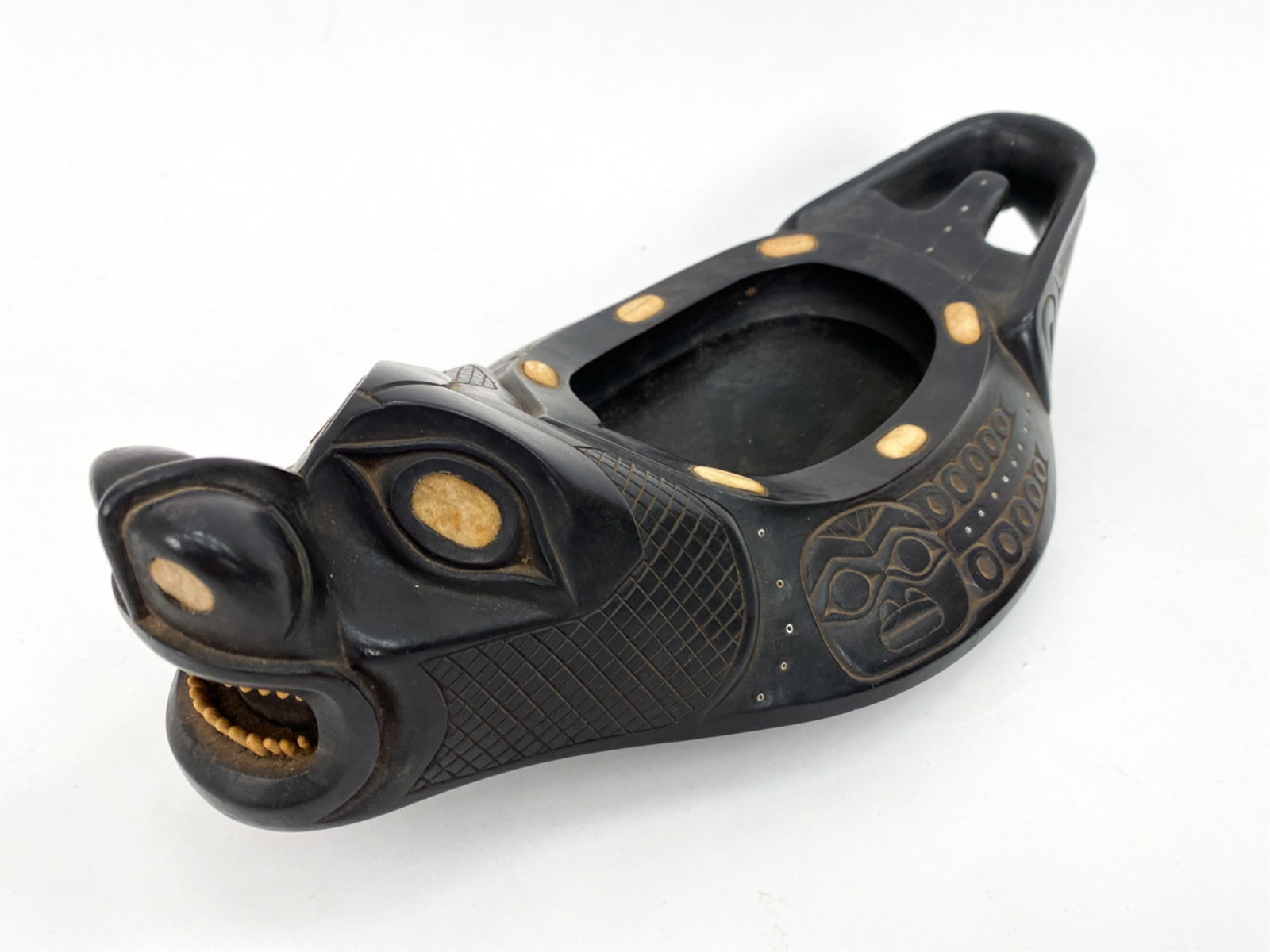 PACIFIC NORTHWEST TINGIT OR HAIDA CARVED BOWL: 20th C. oval bear grease bowl with bear form head. Inlaid with bone and abalone. Unsigned. Dimensions: H 5" x W 14.75" x D 7.5" Condition: Showing some surface wear consistent with age and handling in