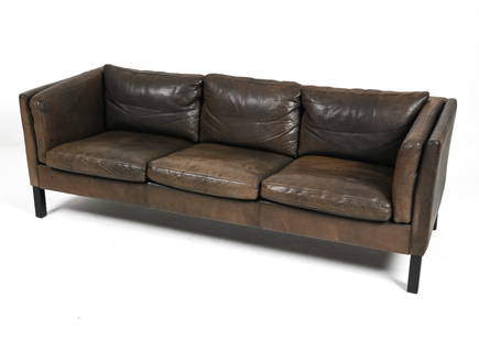 SCANDINAVIAN MODERN BUFFALO LEATHER SOFA: Classic Modern three-seat sofa in the manner of Mogens Hansen, finished in richly patinated dark brown buffalo leather with dark stained beech wood legs. Dimensions: H 26.5" x W 78" x D 28.5" x SH 16.