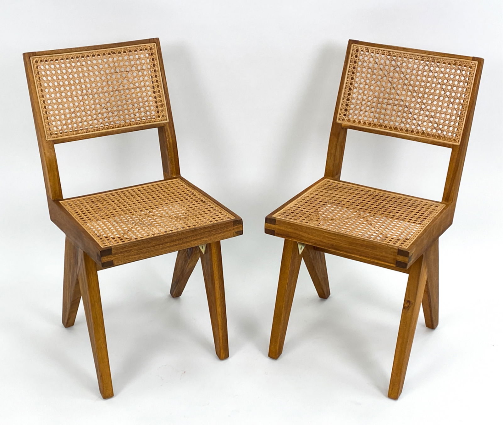 PAIR OF CONTEMPORARY CANED CHAIRS: With caned seat and backrest. Unsigned. Dimensions: H 32.5" x W 15" x D 20" x SH 19.5" Condition: Light fading to a leg. Cane with couple small losses. Few dings and nicks.