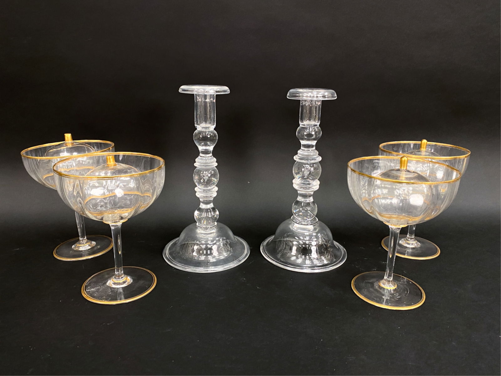 STUBEN CANDLE STICKS AND CRYSTAL CAVIAR GOBLETS: Including a pair of signed Stuben candle sticks and (4) Victorian crystal goblets with ice liners. Dimensions: (Tallest) H 10.5" x D 5.5" Condition: Showing light normal signs of handling/use.