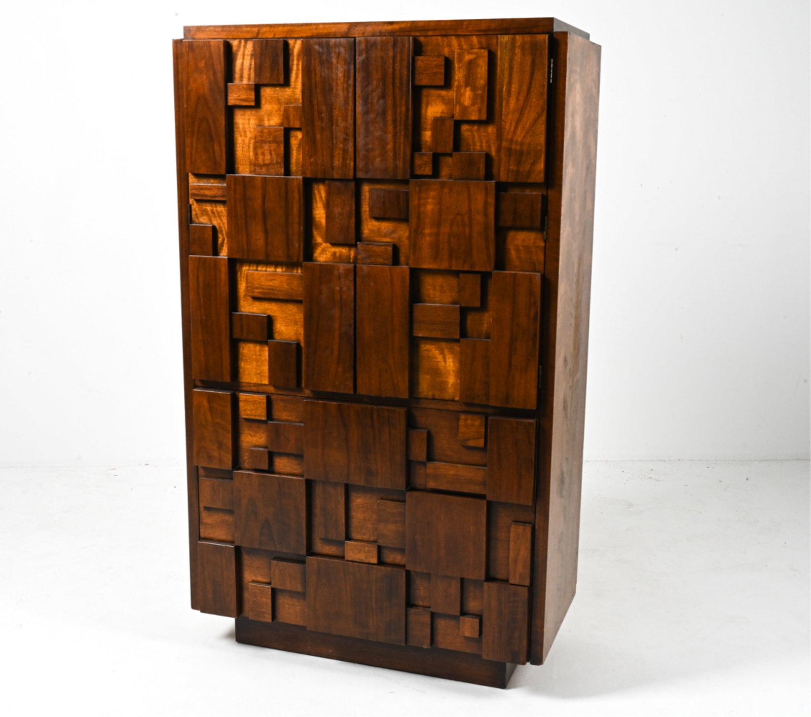LANE BRUTALIST "STACCATO" ARMOIRE IN WALNUT: Fantastic Brutalist highboy chest in the style of Paul Evans, with sculptural patchwork mosaic-style paneling. From the "Staccato" collection by Lane Furniture, c. 1970's. Heat-stamped inside top draw
