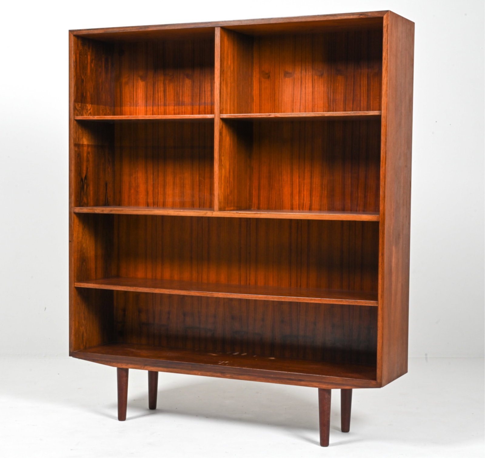 OMANN JUN DANISH ROSEWOOD BOOKCASE: Model No. 5, labeled on back panel. The lowest shelf and the two upper half-shelves are adjustable. Produced by Omann Jun Mobelfabrik, Denmark, c. 1960's. Likely a Gunni Omann design. Dimensions: H 55