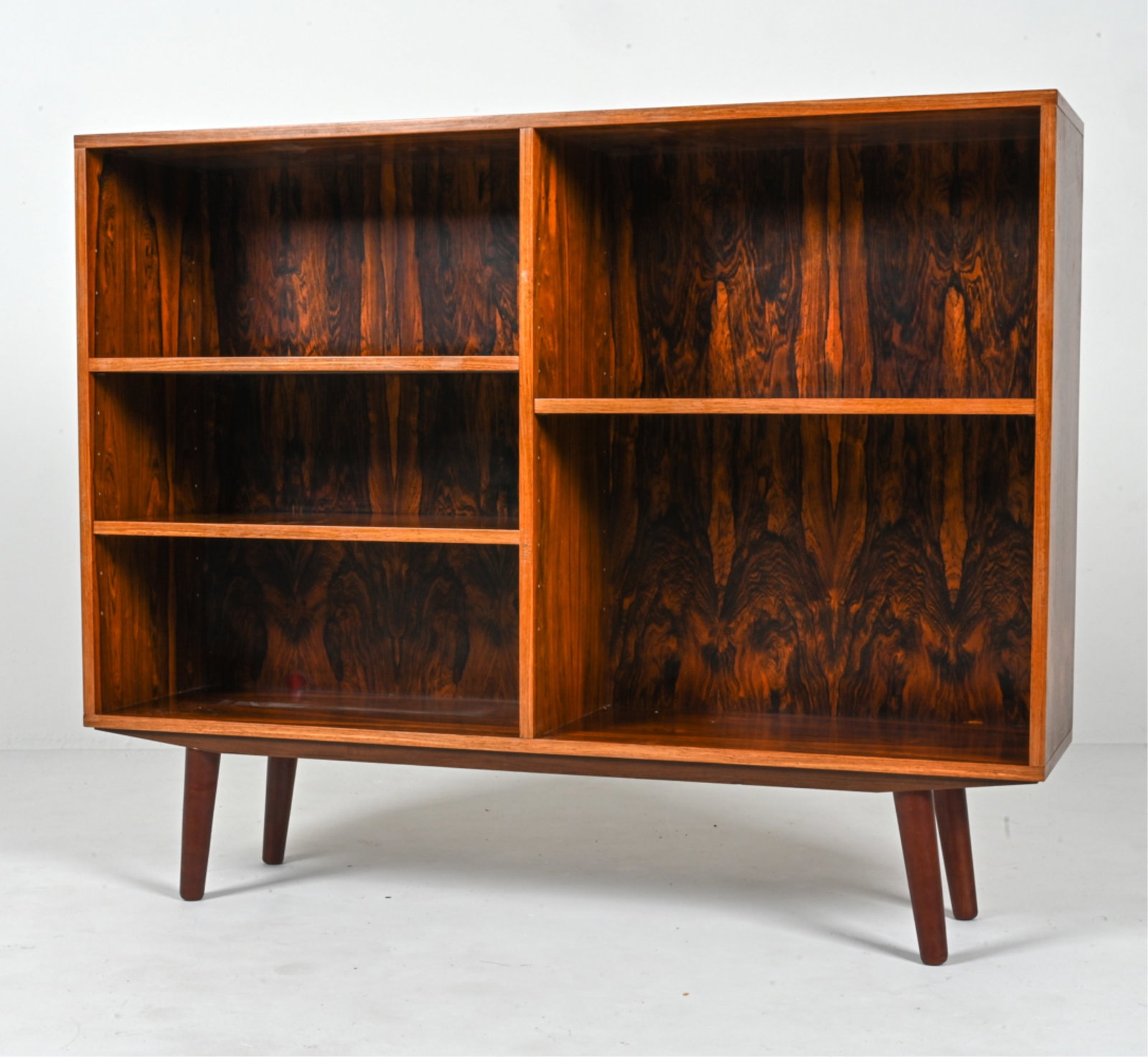 SCANDINAVIAN MID-CENTURY ROSEWOOD BOOKCASE: With adjustable shelves. Apparently unsigned; in the style of Omann Jun, c. 1960's-1970's. Dimensions: H 37.5" x W 46.5" x D 11.5" Condition: Presents very well overall. Minor sun fading to front; a f