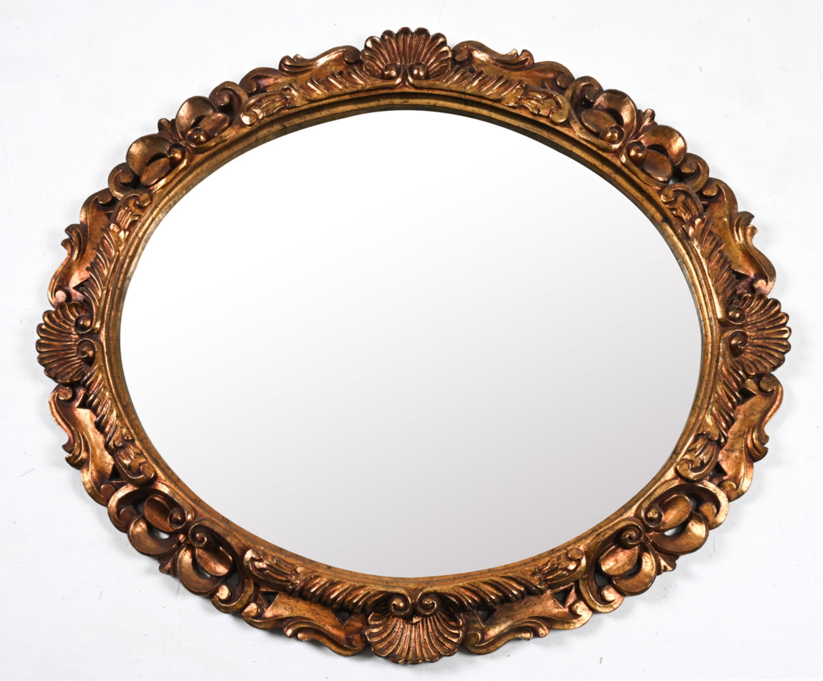OVAL SCROLLED GILT MIRROR: Dimensions: H 36" x W 40" Condition: Intentionally antiqued. In very good vintage condition overall; light wear consistent with age. R68