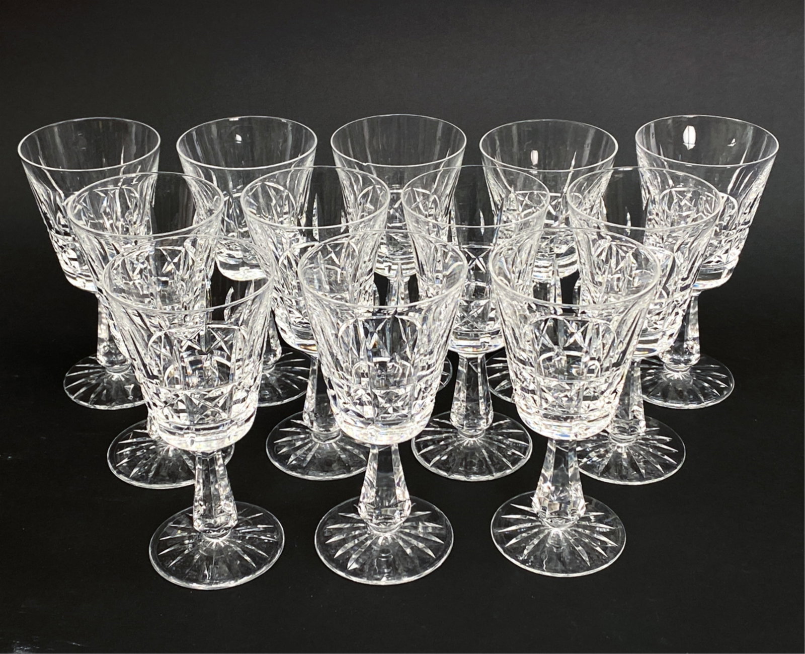 (12) WATERFORD CRYSTAL WINE GLASSES: Set of 12 Clear-cut crystal, unmarked. Dimensions: H 6.25" Condition: Couple flea bites to rims. Handling wear including, scratches, etc.