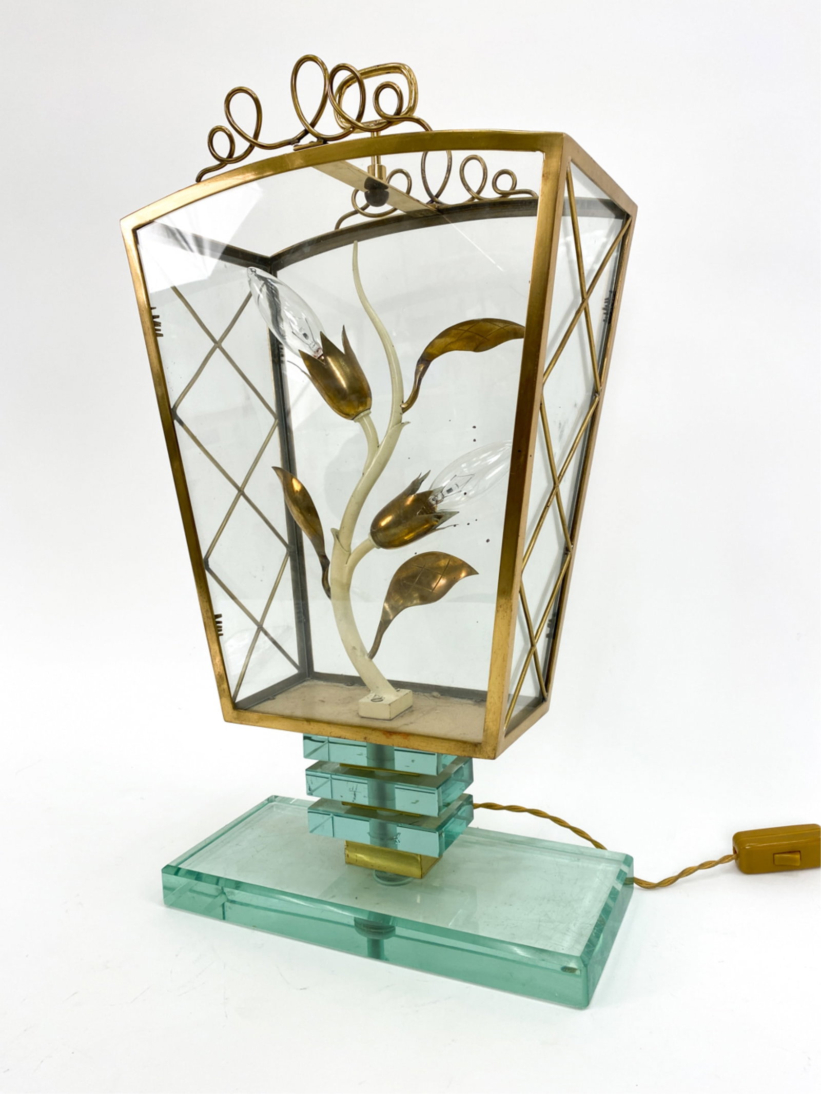 MANNER OF FONTANA ARTE ITALIAN GLASS LAMP: Painted tole floral form lamp on a geometric glass base. Brass and glass integral shade. Dimensions: H 21" x W 12" x D 6.5" Condition: Minor surface wear consistent with age and use. Untested.