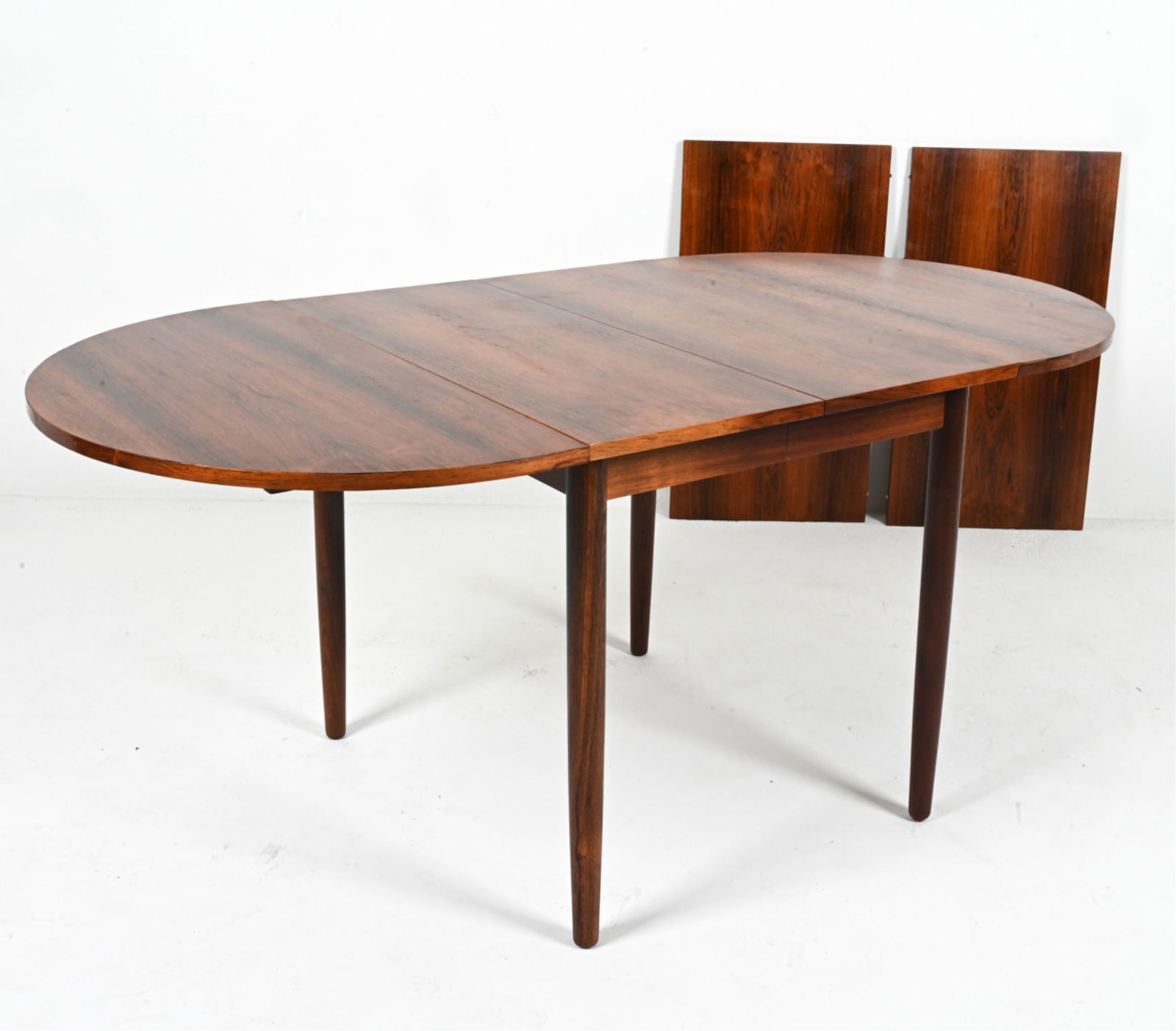 ARNE VODDER FOR SIBAST ROSEWOOD DINING TABLE: Danish, c. 1960's. With (2) inset leaves and (2) drop-leaves. Dimensions: (Without leaves) H 28.5" x W 27.5" x D 33.25" ; Inset leaf measures 17.75" wide; drop leaf measures 19" wide. Condition: Prese