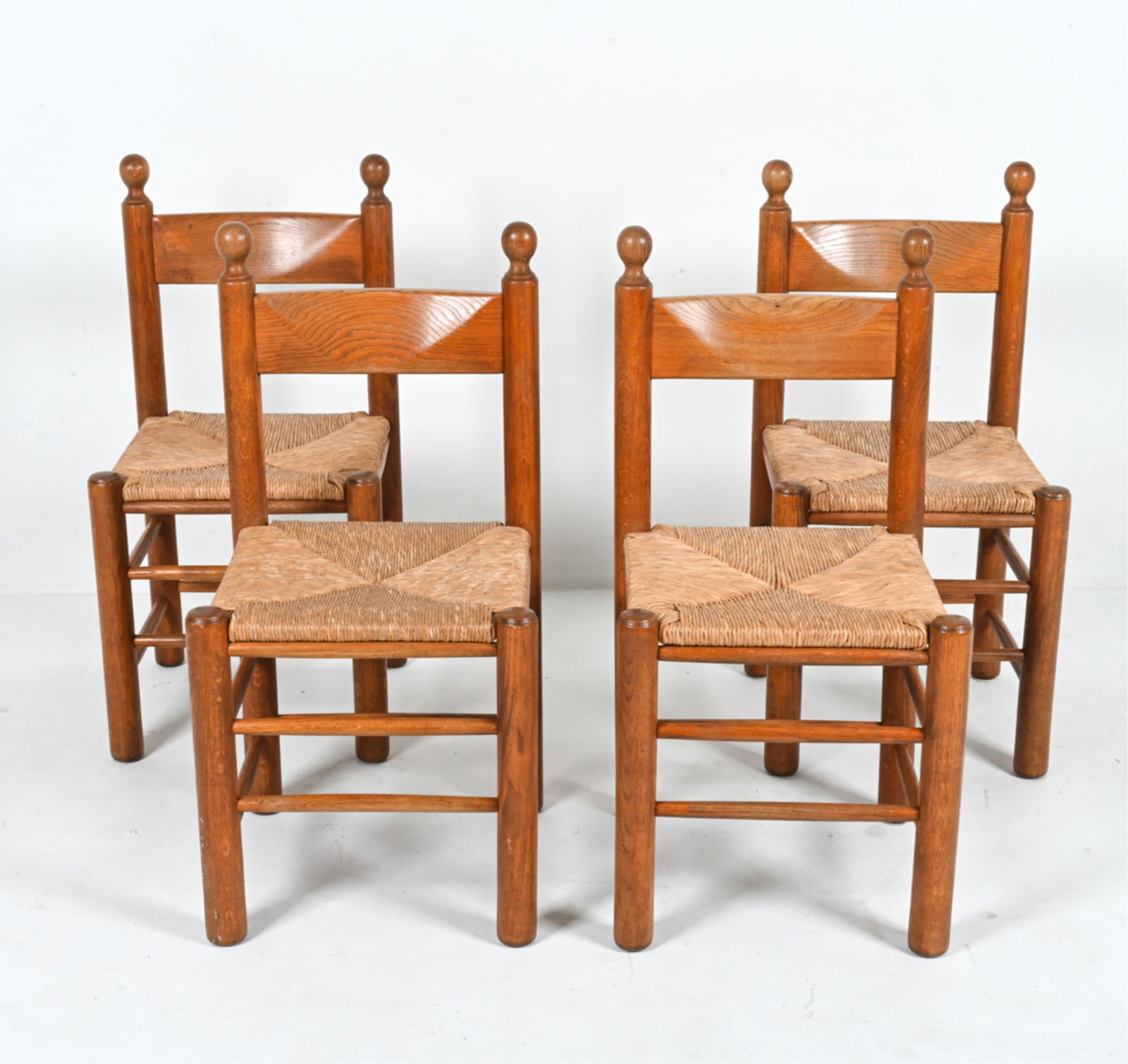 (4) MANNER OF MAGISTRETTI OAK & RUSH DINING CHAIRS: In the manner of Vico Magistretti or Charles Dudouyt. Europe, c. 1960's. Dimension: H 36" x W 18" x D 17" x SH 19" Conditions: In very good vintage condition overall. Frames with some fading, minor sc