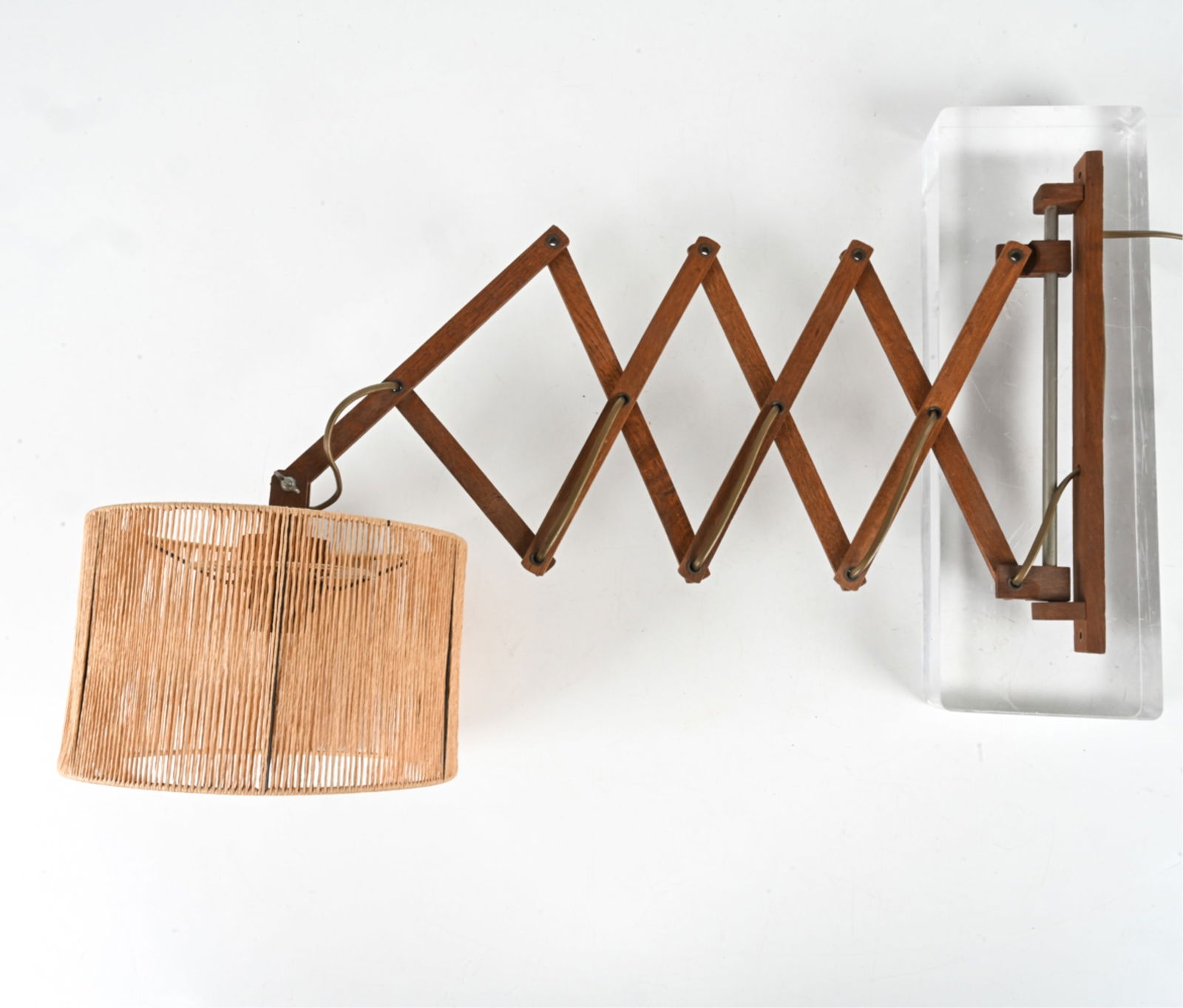 STYLE OF LE KLINT OAK SCISSOR-ARM WALL LAMP: Accordion-arm sconce in oak with jute shade, in the style of Eric Hansen for Le Klint. European, c. 1960's. Dimensions: (With shade, arm compressed) H 18.5" x W 15.5" x D 10.25" ; With arm fully exten