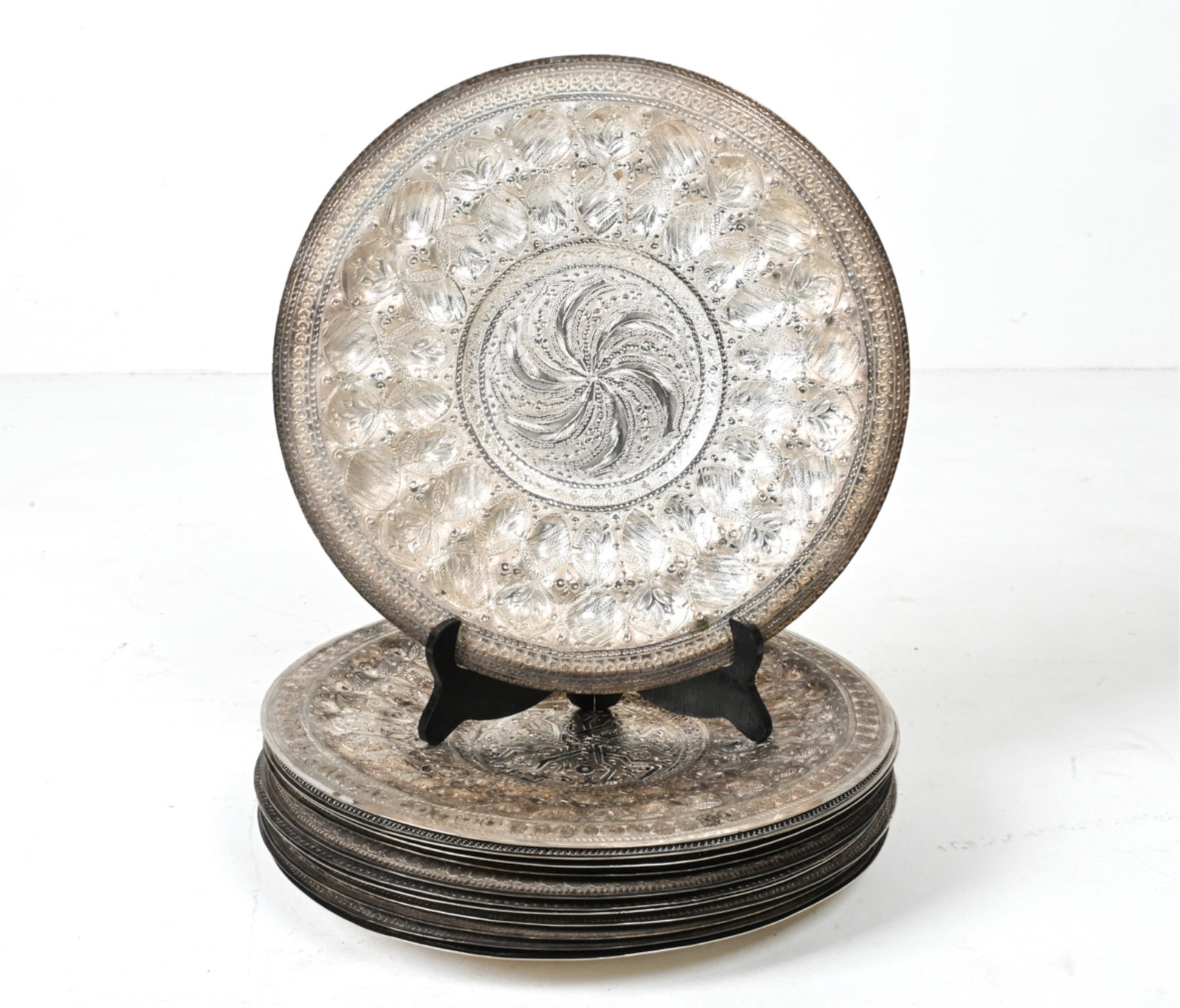 (12) ISRAELI REPOUSSE SILVERPLATE CHARGERS: Signed underneath. Dimensions: Dia. 14" Condition: Grouping presents very well overall. Minor surface tarnish; a few rubs to plating, a few small spots of oxidation.