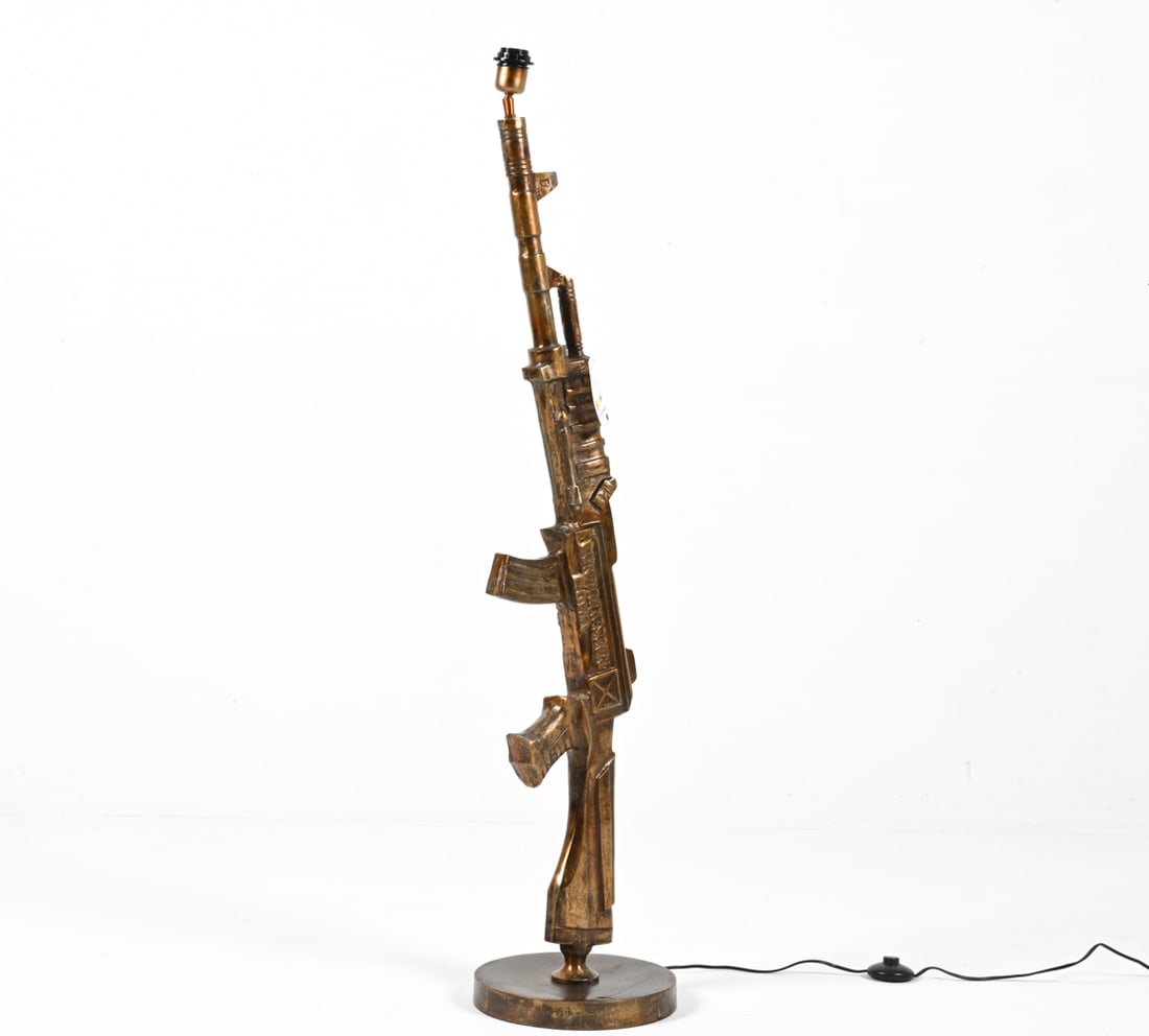 MACHINE GUN FLOOR LAMP: In the manner of Philippe Starck. Cast resin with bronze finish. Produced in Europe. Contemporary. Dimensions: H 51" x Dia. 11" Condition: European plug; wiring not tested - will require rewiring or a