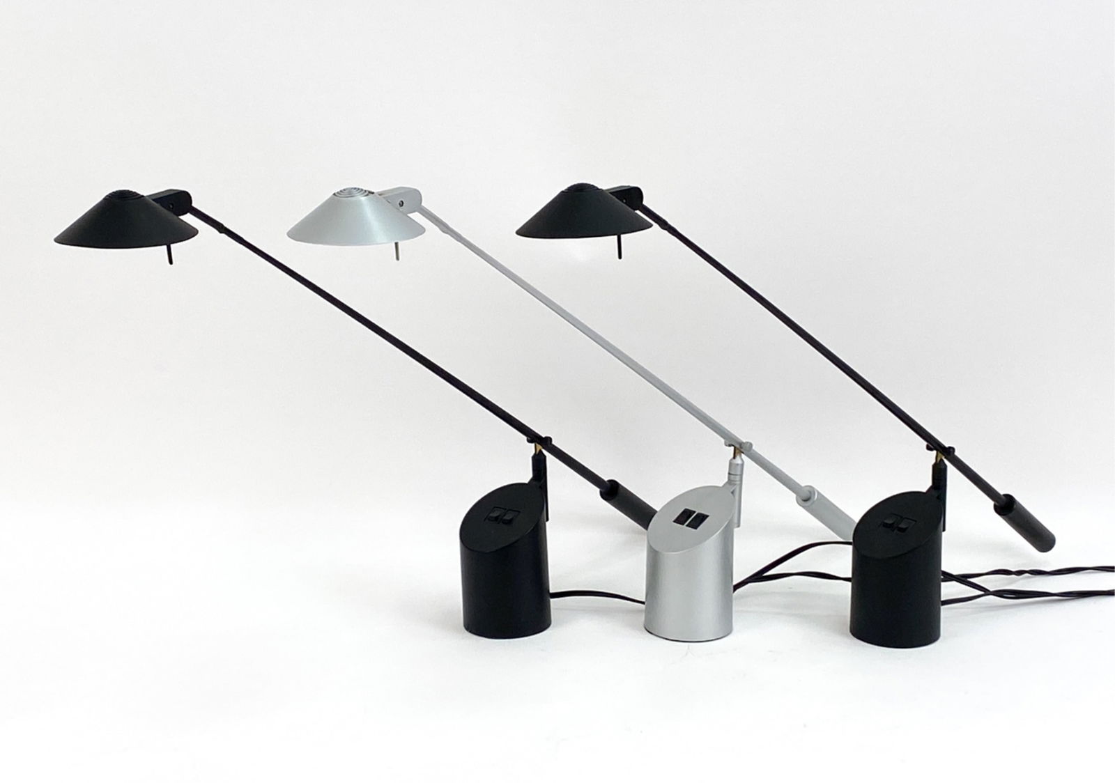 (3) "FEATHER" TASK LAMPS BY SONNEMAN FOR KOVACS: Three Postmodern "Feather" desk lamps, designed by Robert Sonneman for George Kovacs in 1989. (2) Black, (1) silver; labeled underneath. These iconic lamps are in the MoMA Collection. Dimensions: H 23