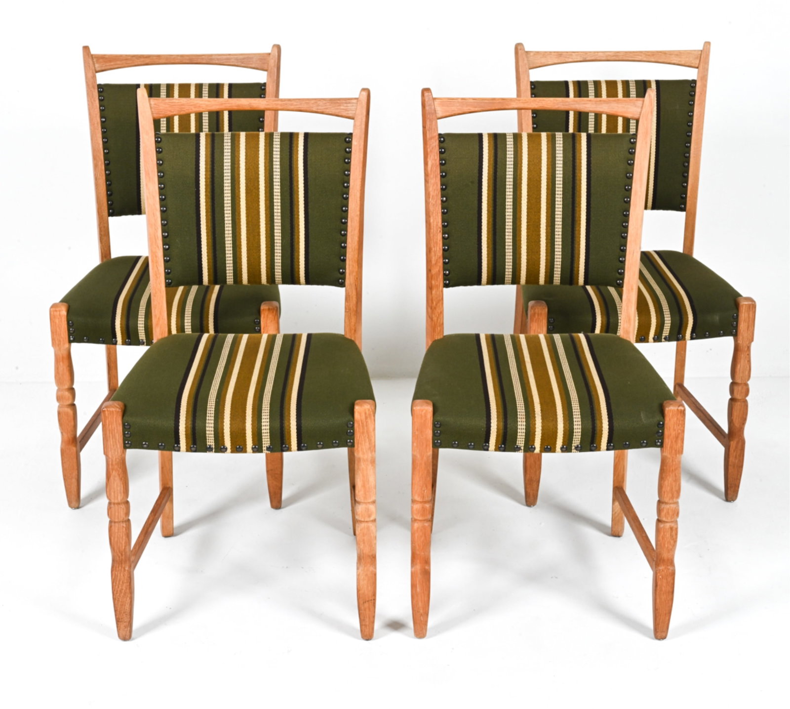 (4) MANNER OF HENNING KJAERNULF OAK DINING CHAIRS: Scandinavian, c. 1970's. Dimensions: H 36.75" x W 18.75 x D 18.75" Conditions: Stress crack to one leg. In good vintage condition overall; a few water spots to frames, some soiling to fabric. Wear con