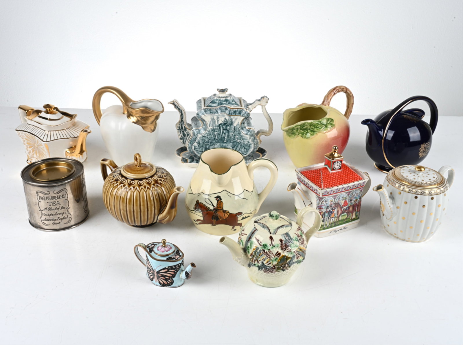 GROUPING OF TEAPOTS & PITCHERS: Including one tea caddy. Dimensions: (Largest) H 8" x W 9" x D 6.5" Condition: Showing various signs of light wear consistent with age and use; a few tiny nicks to spouts, some rubbing to decoration; 