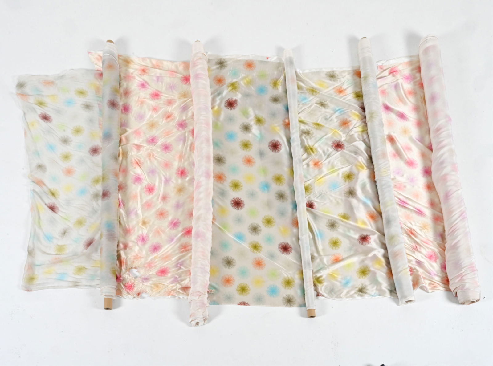 OVER 40 YARDS OF CUSTOM PRINTED SILK FABRIC: Silk satin and silk chiffon; with multicolor dandelion / starburst print. One roll with original order label from Frangi S.P.A., Italy, stating fabric content of 100% silk. Dimensions: (Largest roll)