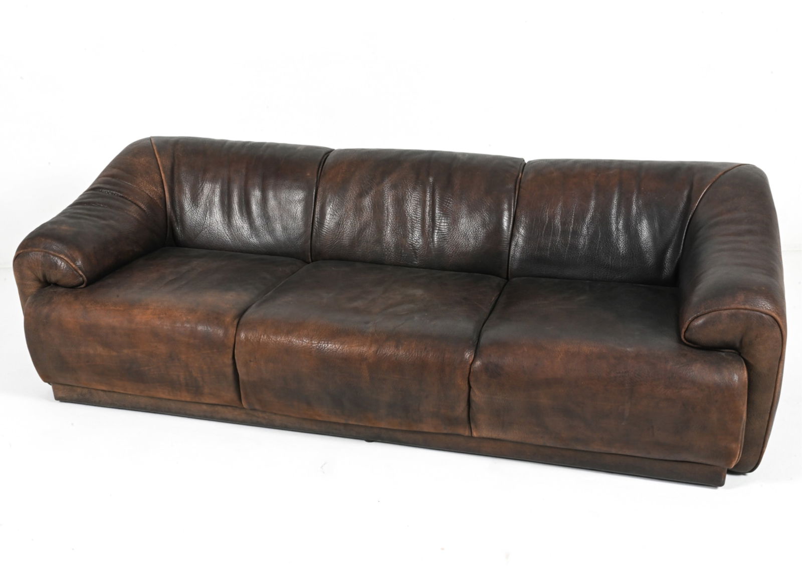 MANNER OF DE SEDE BUFFALO LEATHER SOFA, C. 1970'S: Three-seat sofa in luxurious patinated buffalo leather, in the style of De Sede. Netherlands, c. 1970's. Dimensions: H 28" x W 88" x D 37.75" x SH 13.5". Condition: Leather with rich natural patinatio
