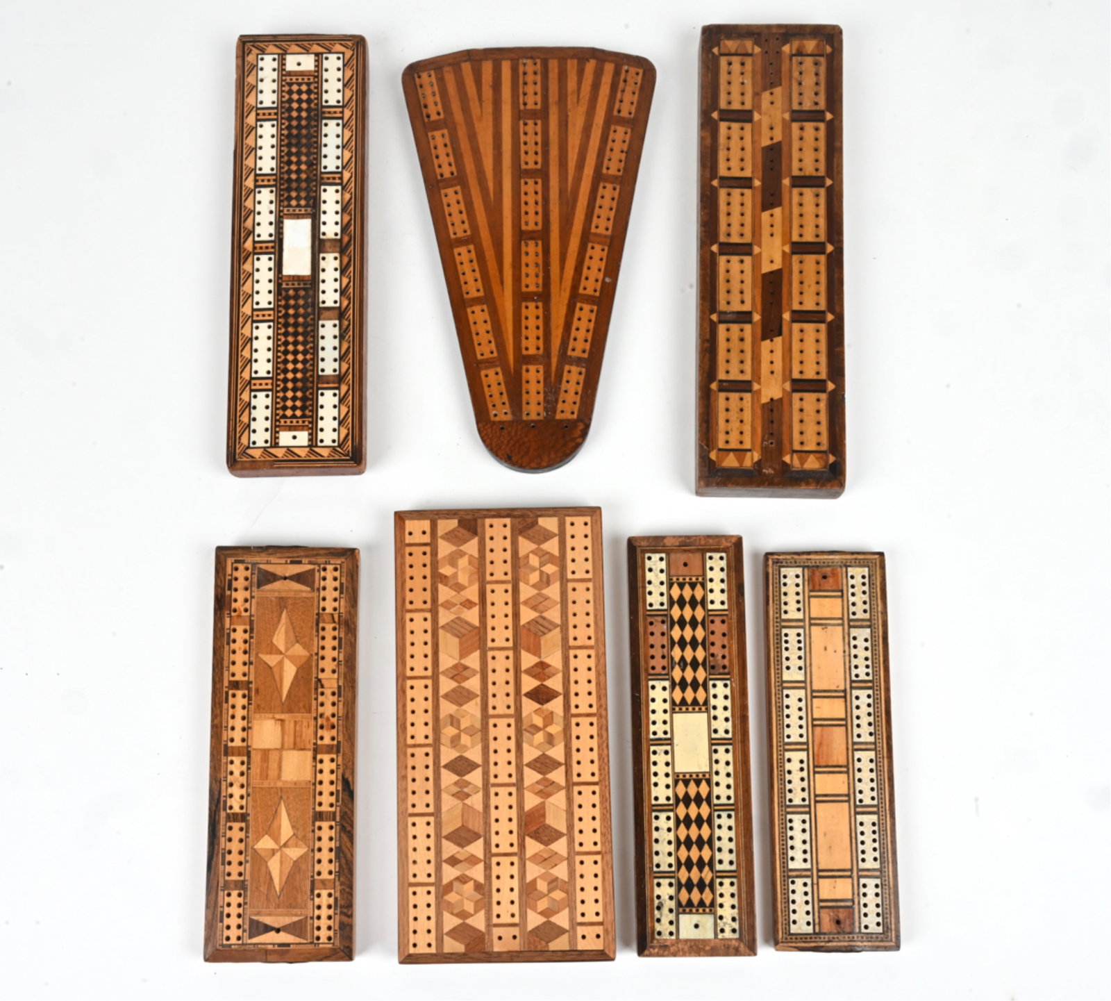 (7) HAND-CRAFTED INLAID WOOD CRIBBAGE GAME BOARDS: (7) Group of cribbage game boards. Hand-crafted, with wood and bone inlay. Vintage and antique. Dimensions: (Largest) H 11.5" x W 5.5". Condition: Small losses to veneer, some pieces of inlay missing.