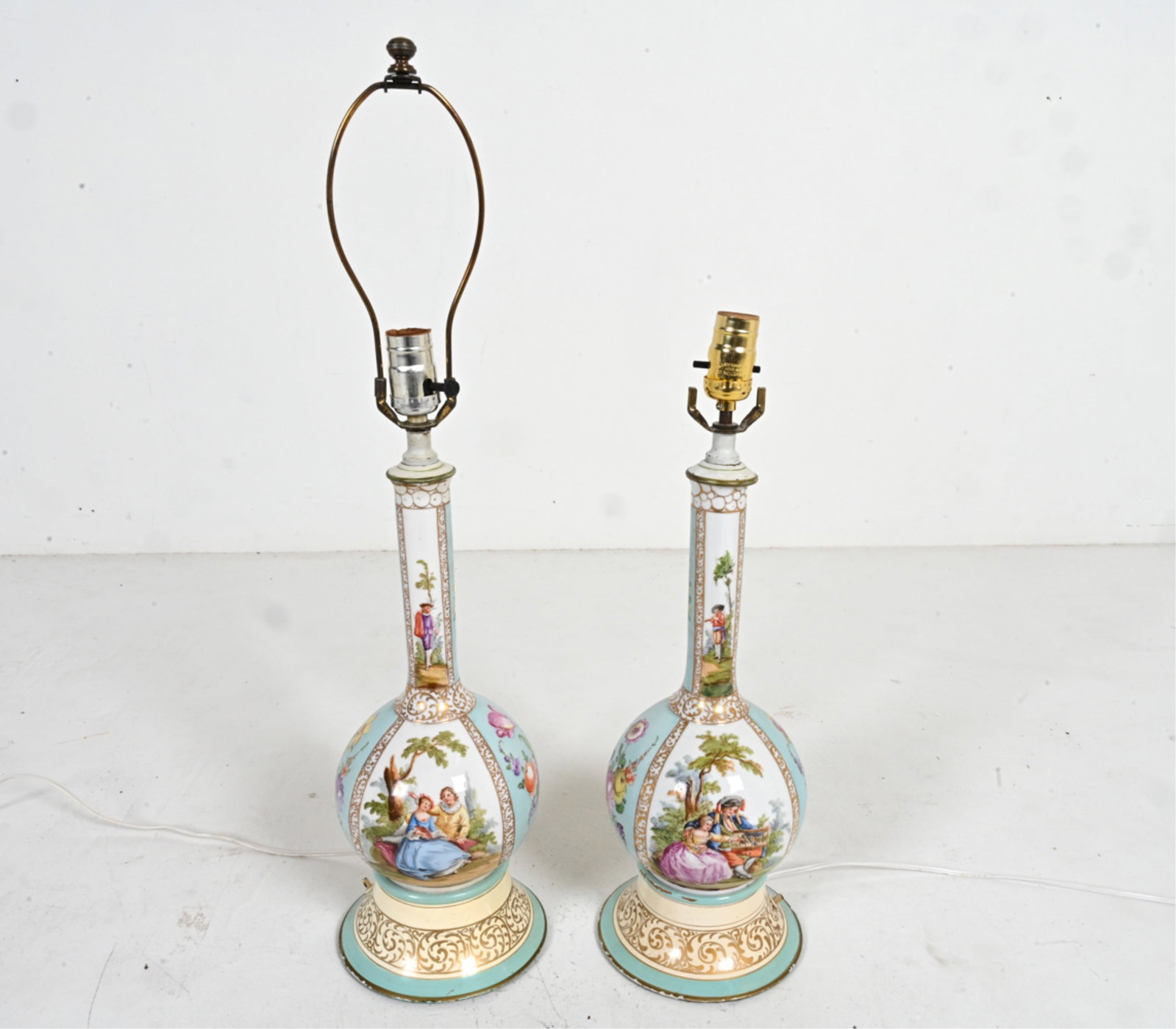 PAIR OF PORCELAIN LAMPS: Pair of porcelain painted lamps with floral and pictorial designs. Dimensions: (Tallest, as shown) H 27" x Dia. 16". Condition: Showing signs of wear including small chips , losses to bottom edges. Wi