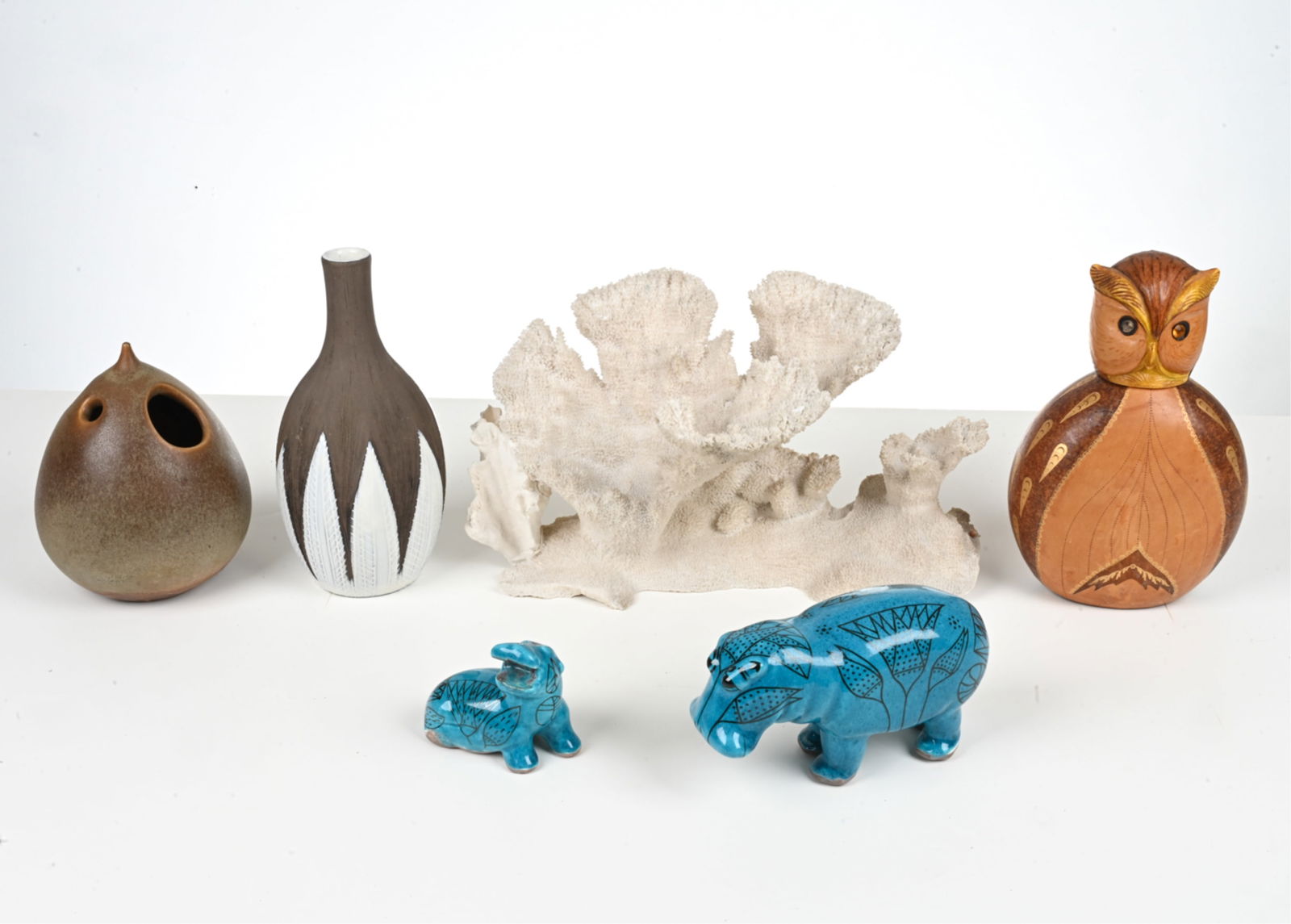 DECORATIVE GROUPING: Group of (6) decorative objects including 4 pottery items, 1 leather covered bottle, and 1 coral specimen. Dimensions: (Coral) H 8.75" x W 15" x D 8.5". Condition: Minor losses to finish on one hippo,