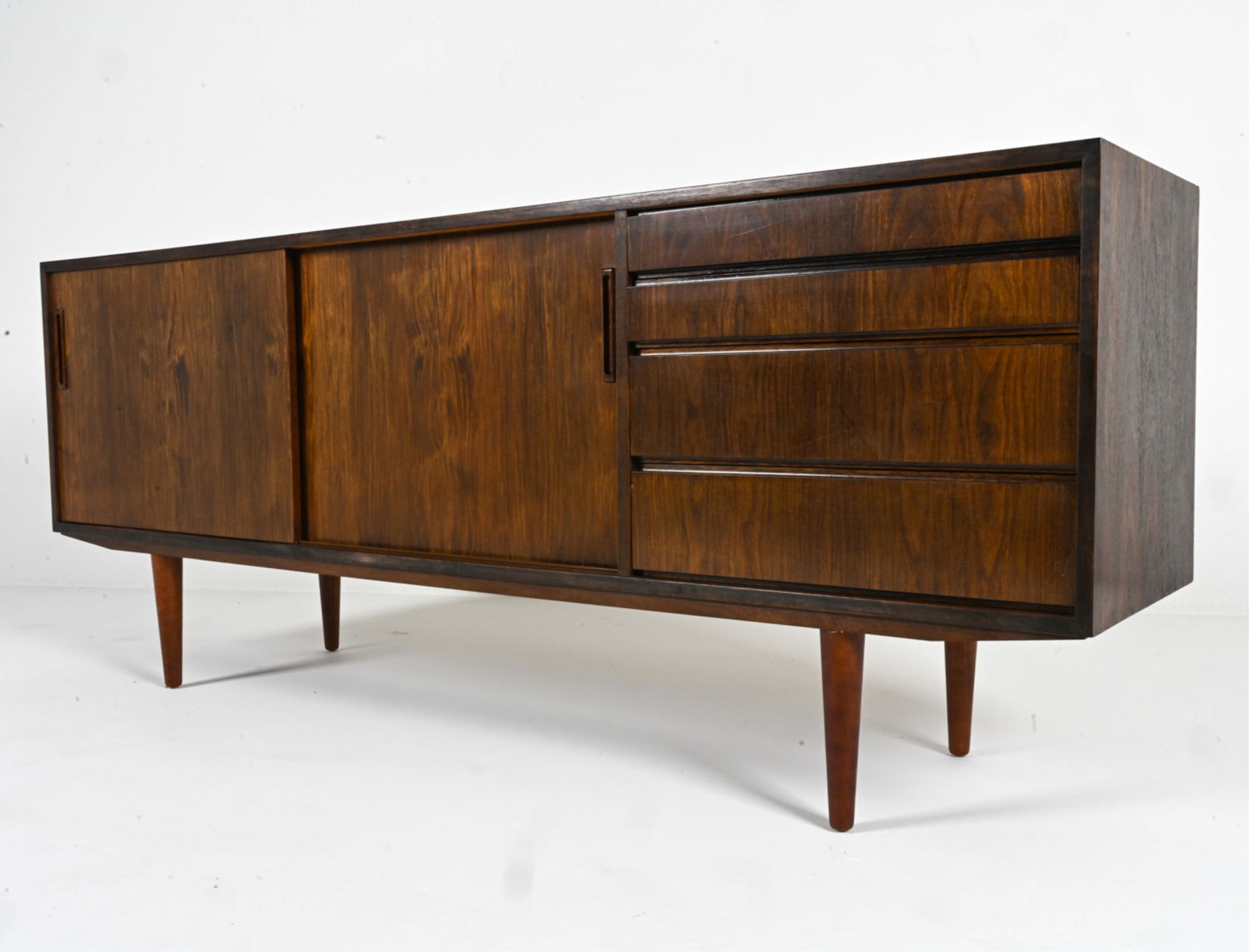 MANNER OF ARNE VODDER ROSEWOOD SIDEBOARD: Two drawers have green felted bottoms. Shelves adjustable. Denmark, circa 1960's. Dimensions: H 31.5" x W 79.5" x D 17.5". Condition: Wear expected from age and use. DMD 134