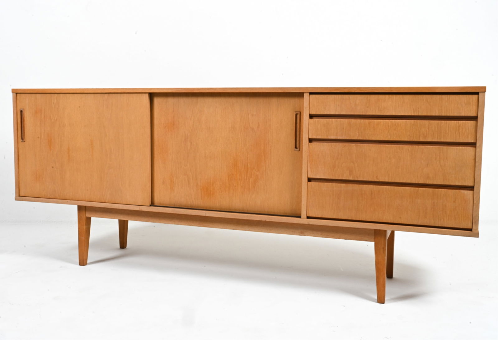 MANNER OF ARNE VODDER OAK SIDEBOARD: Mid-century Modern sideboard in light oak, with adjustable shelves and four drawers. Interior finished in teak veneer. In the manner of Arne Vodder. Scandinavian, c. 1960's. Dimensions: H 32" x W 78.5
