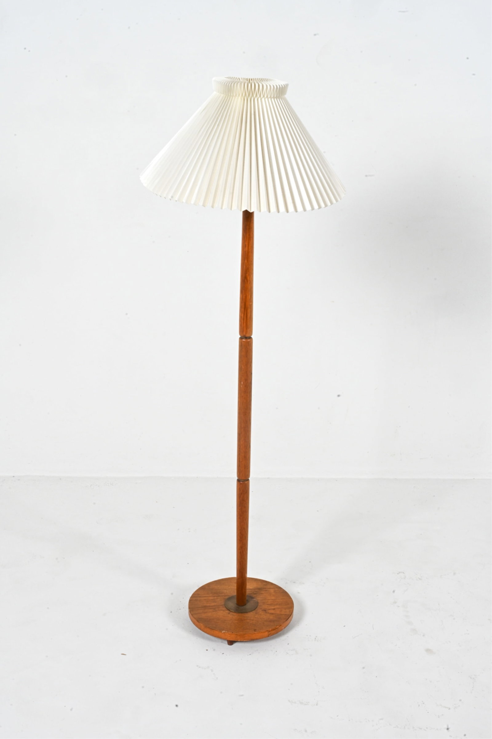 SCANDINAVIAN MID-CENTURY TEAK FLOOR LAMP: Dimensions: (With shade) H 51.75" x Dia. 17.75" Condition: Rewiring required. Some losses to teak veneer at edge of base. A few scuffs and faint water spots to wood scattered throughout. Patination to