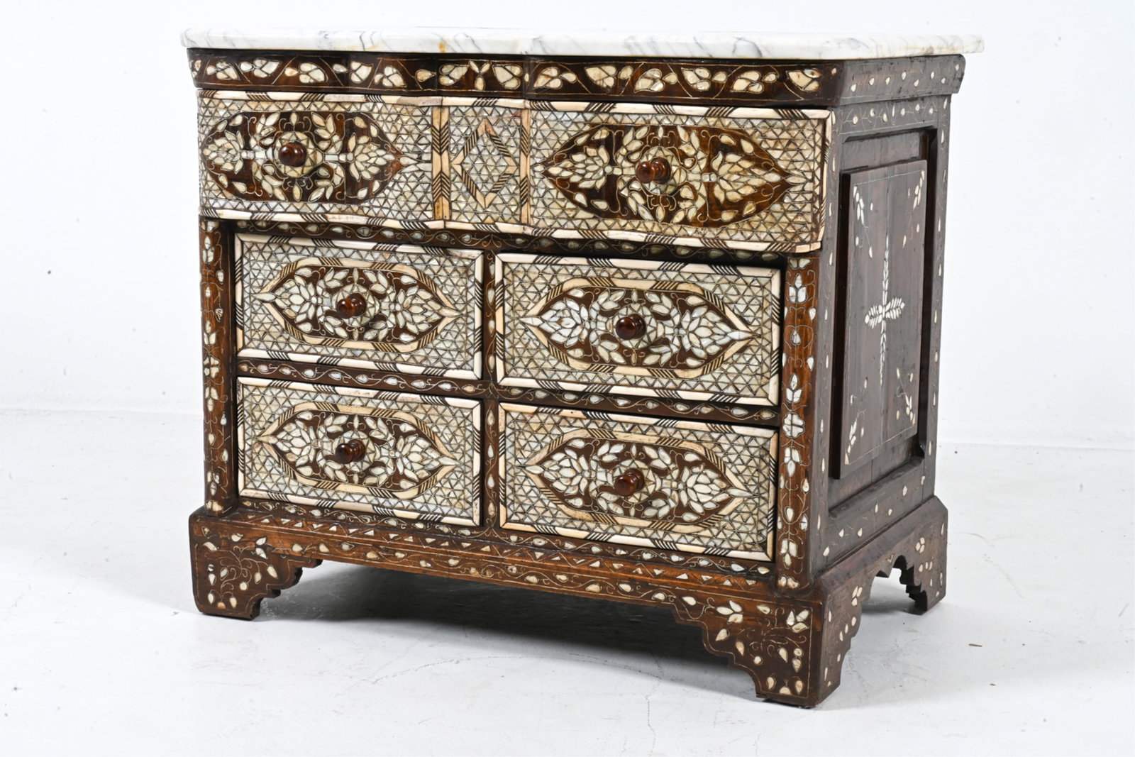 SYRIAN MOTHER-OF-PEARL INLAID MARBLE TOP CHEST: Dimensions: H 26.75" x W 30.25" x D 19" Condition: Surface wear includes minor discoloration of marble top. Minor cracking and chipping of design. Surface wear consistent with age and use.