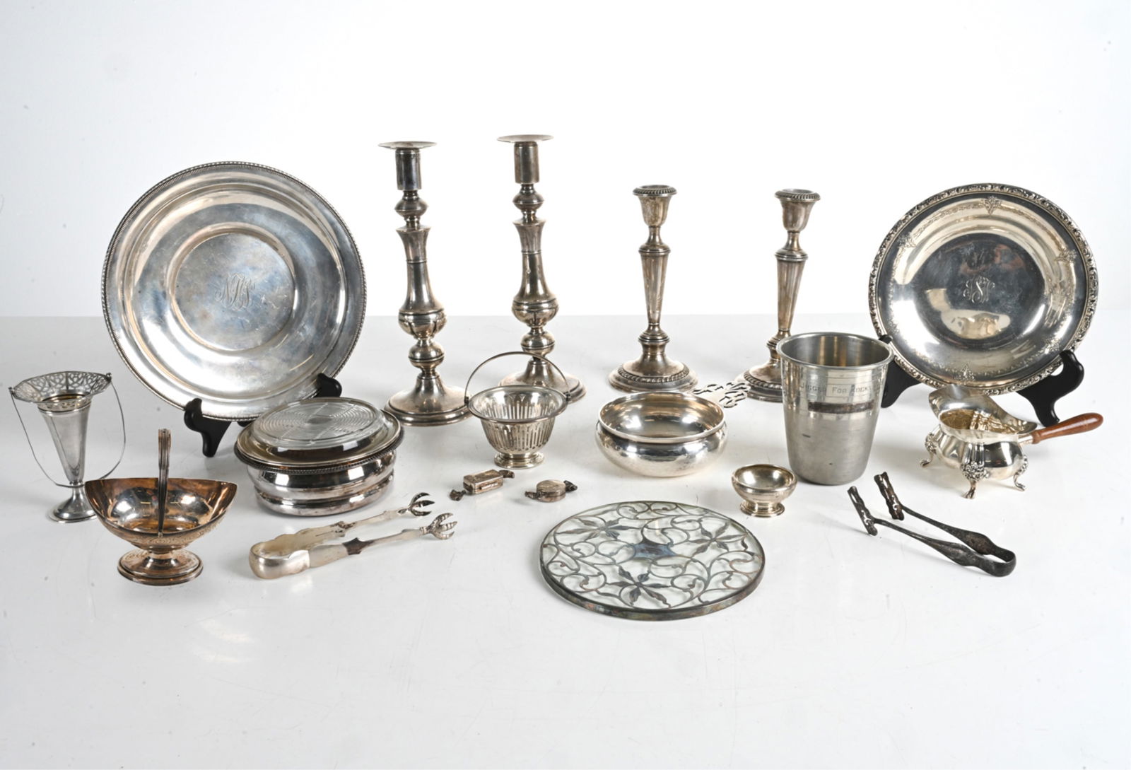 GROUPING OF STERLING & SILVER-MOUNTED TABLEWARE: Including a Tiffany & Co. finger bowl, a porringer and pair of solid sterling candlesticks by Pratt, (2) pill boxes in the form of hard candy, and various others. Dunhill "Just a Thimble Full" cocktai