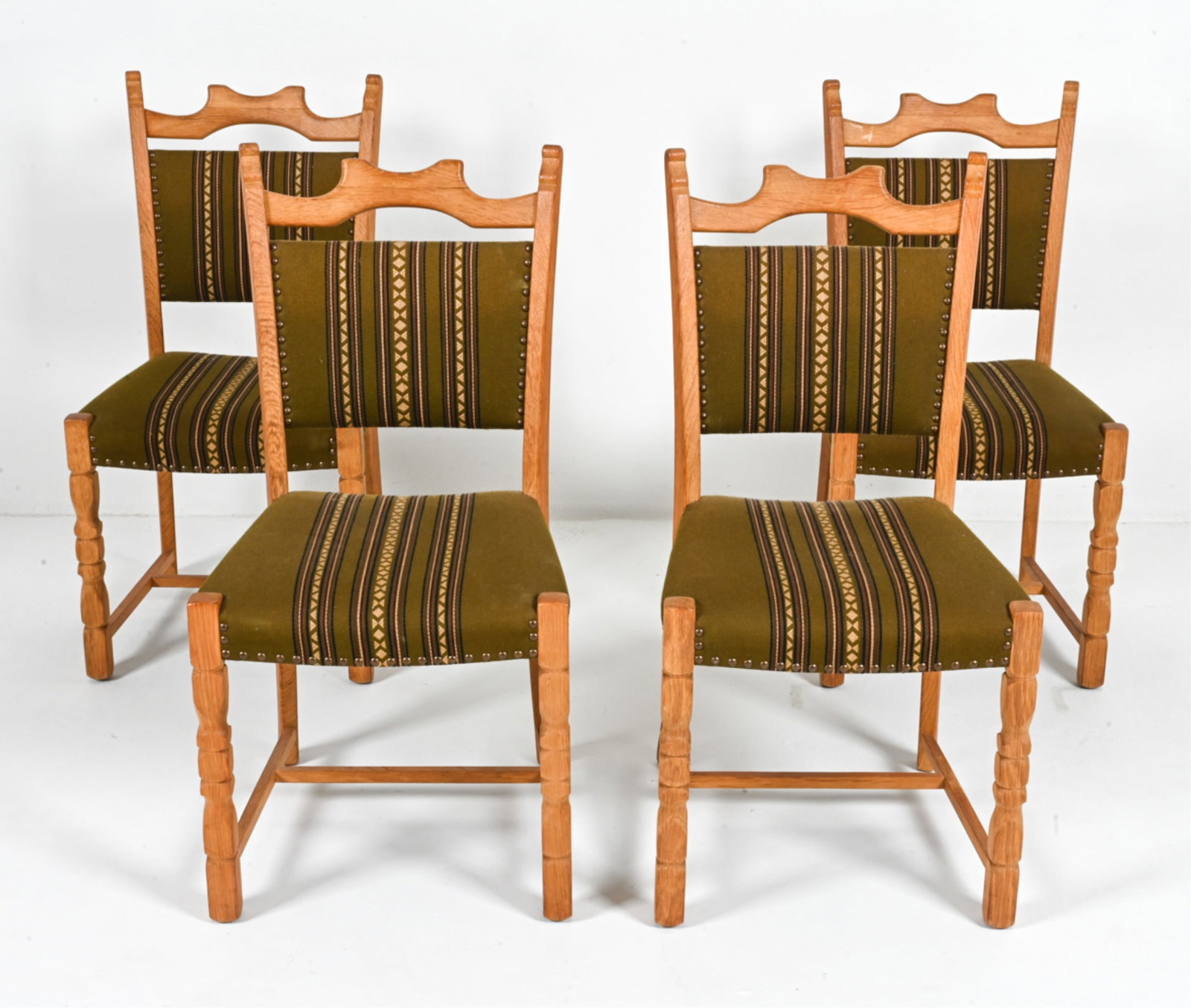 (4) MANNER OF HENNING KJAERNULF OAK DINING CHAIRS: Scandinavian, c. 1970's. Dimensions: H 37" x W 18.5" x D 22" x SH 17" Condition: Minor sun fading, a few water spots and rubs to wood. A few spots of soiling to fabric. Light surface wear consistent w